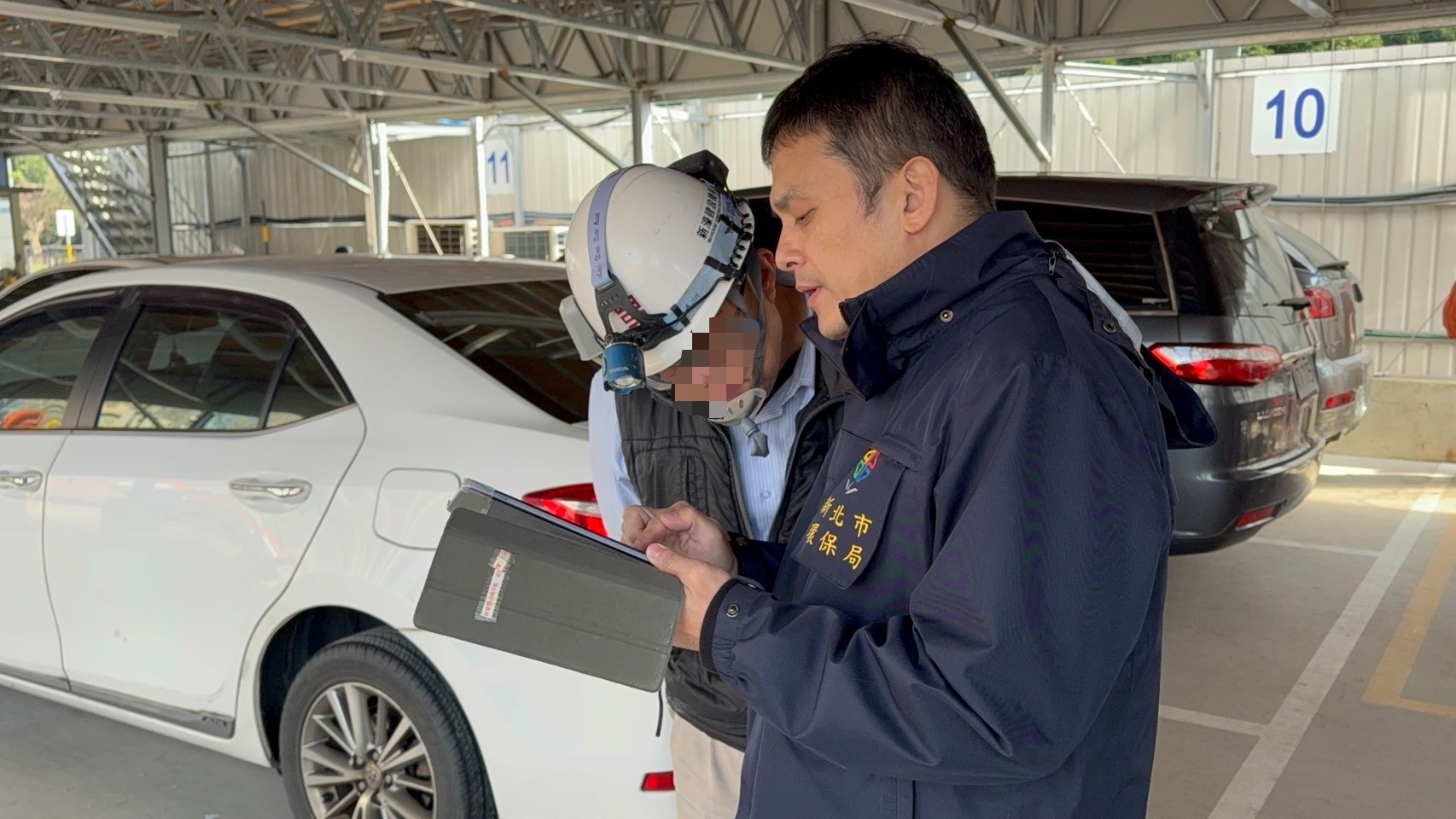 稽查員與土紅色沉積之廠商確認污染範圍，並要求立即清除