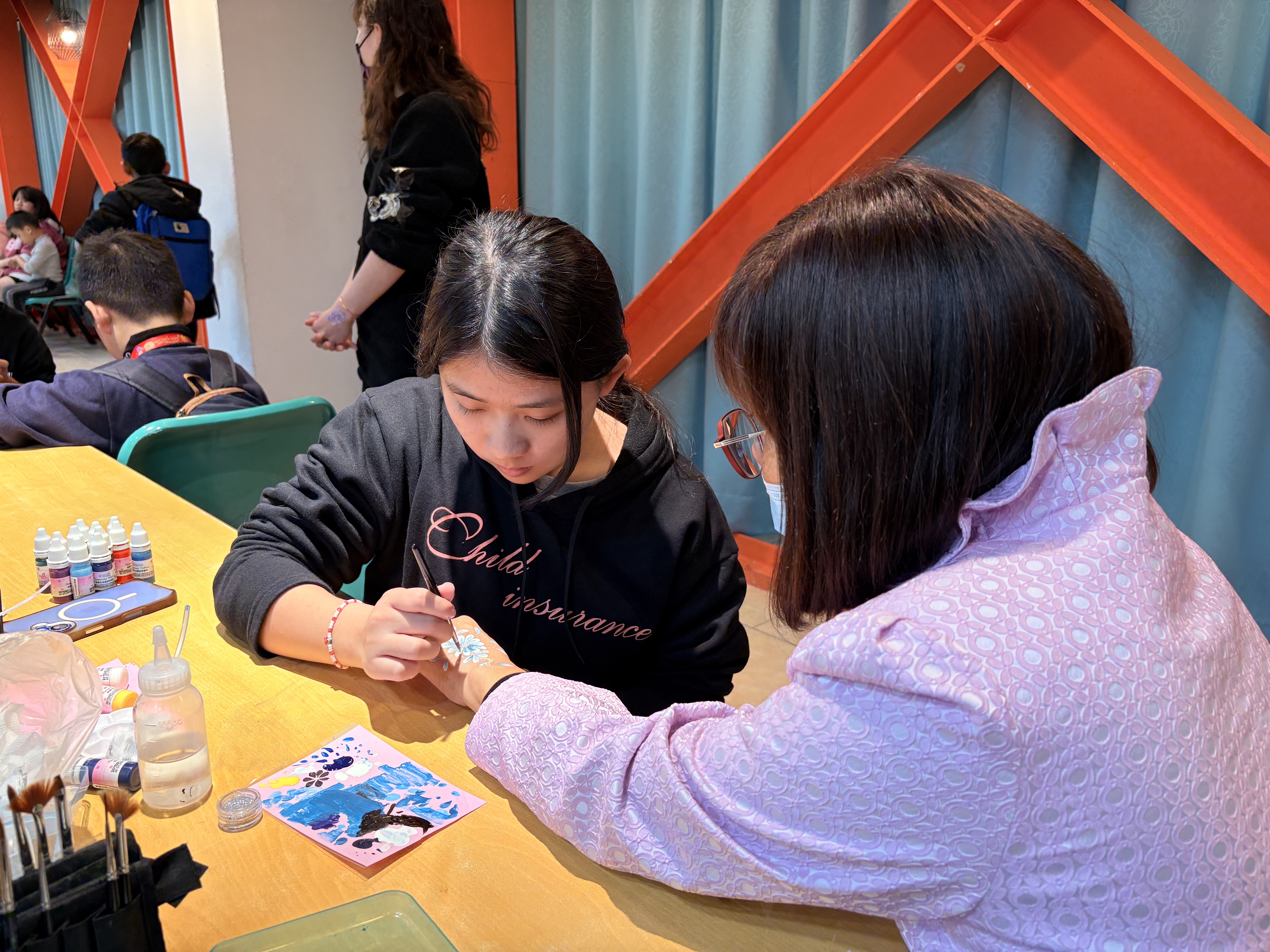 莊敬高職美容科學生發揮專業，為愛心圍爐活動參加者進行人體彩繪體驗