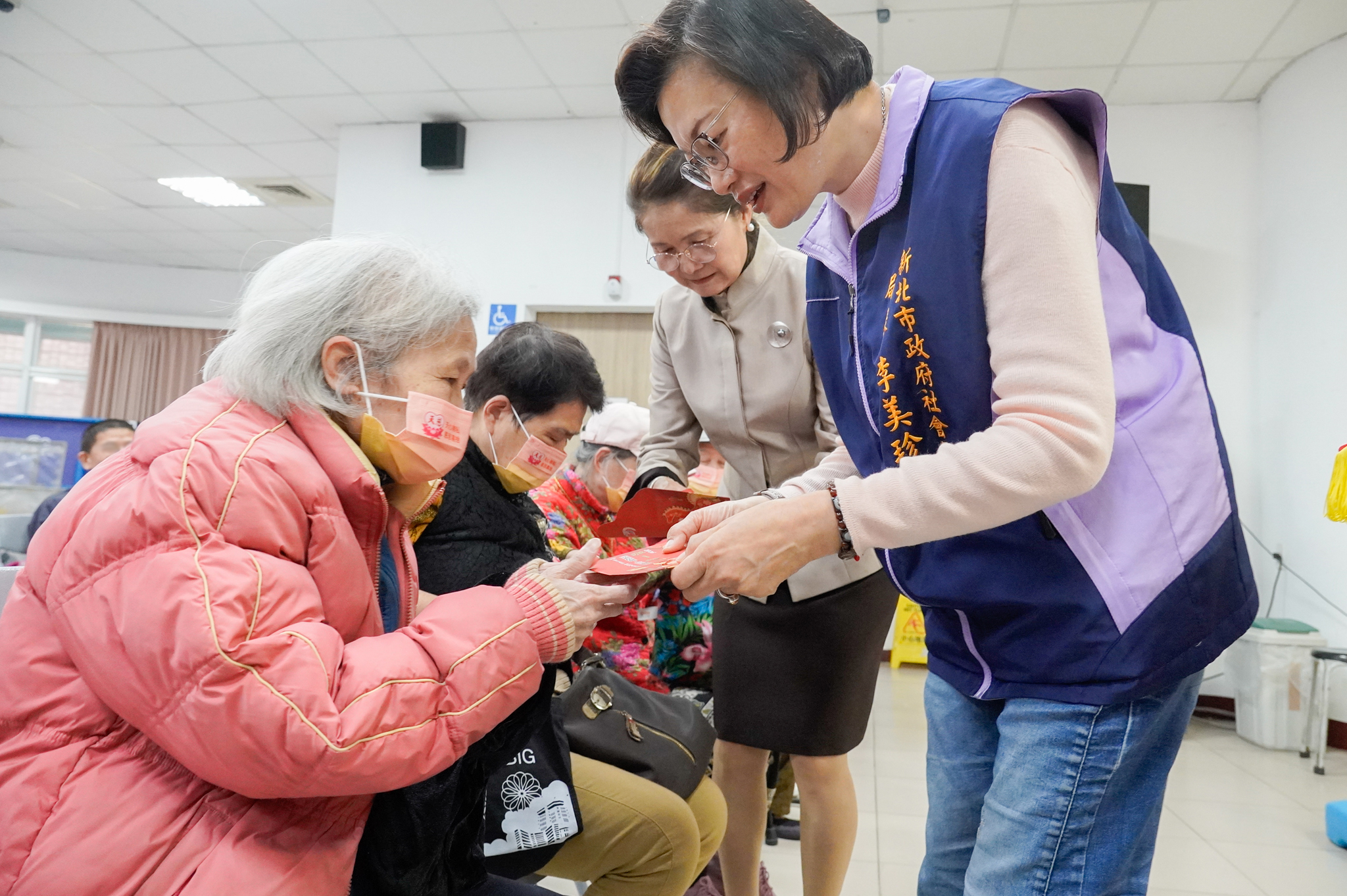 李美珍局長(右)與鄭呂碧雪理事長(中)發放關懷金給弱勢民眾