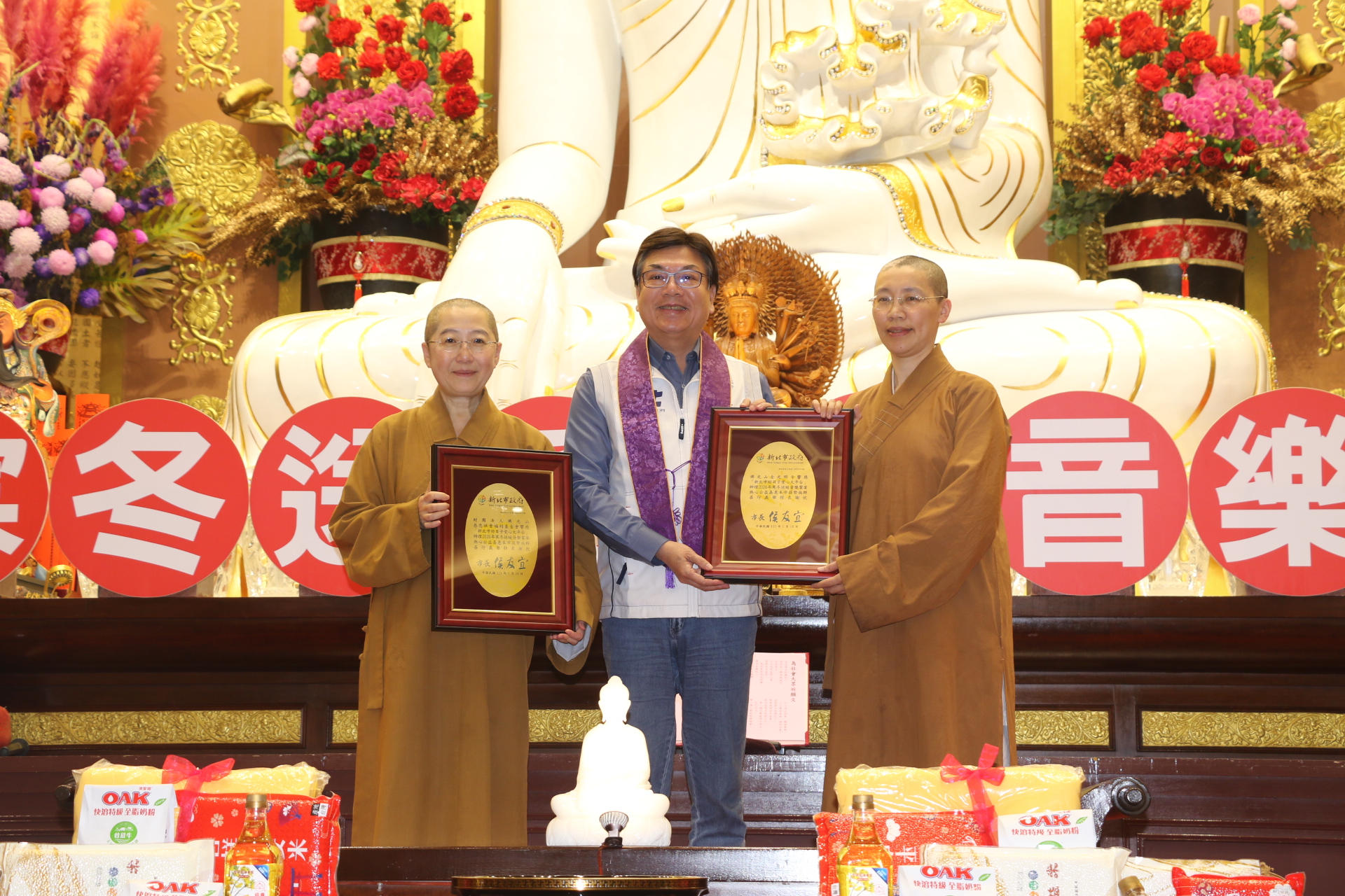  劉和然代表侯友宜市長頒贈感謝牌給覺培師父（左）和有果師父（右）