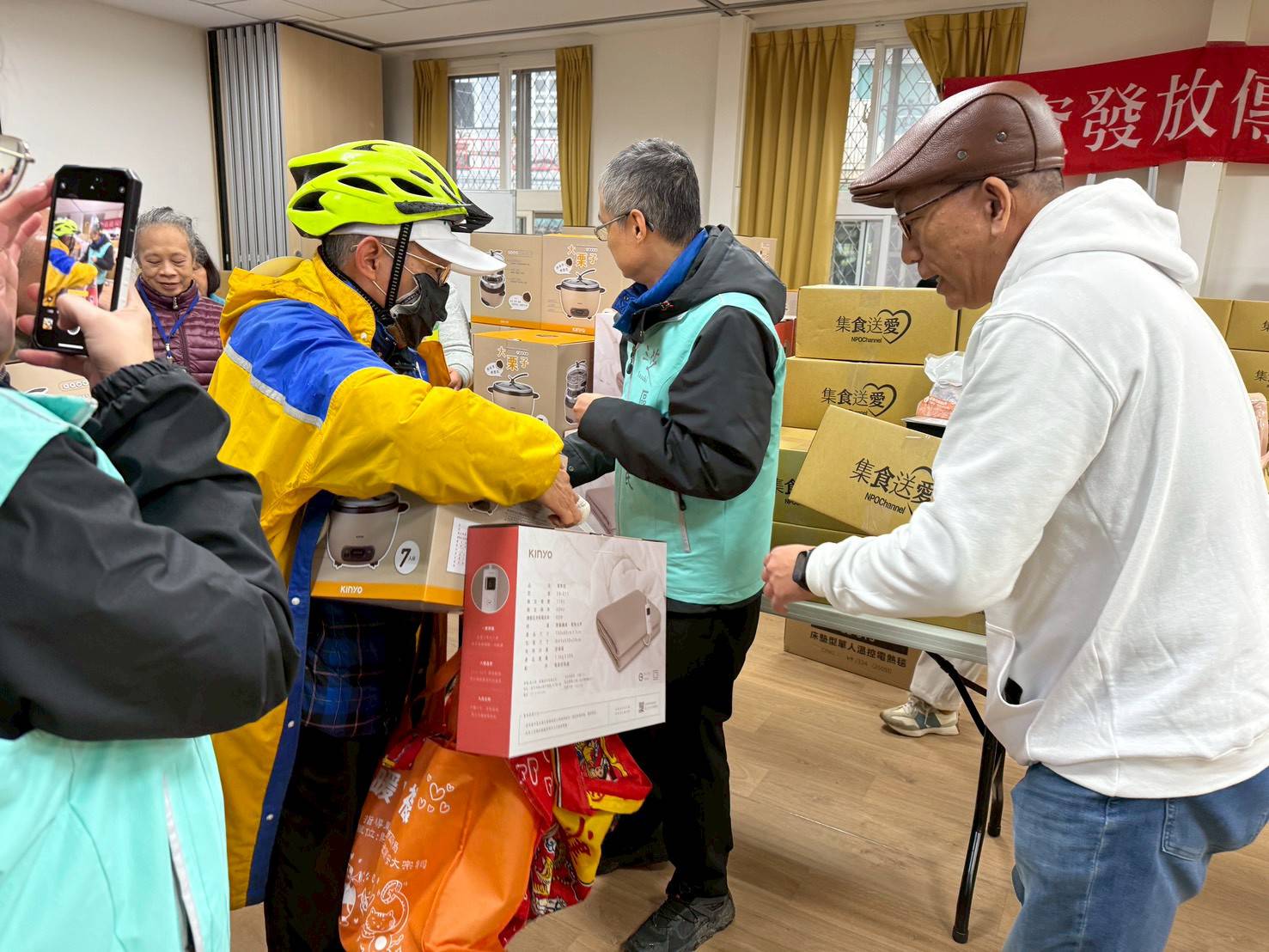 NPO channel公益平台創辦人張幼霖（右）和三芝區長李天民（右2）一起致贈電鍋、電熱毯和年菜給弱勢戶