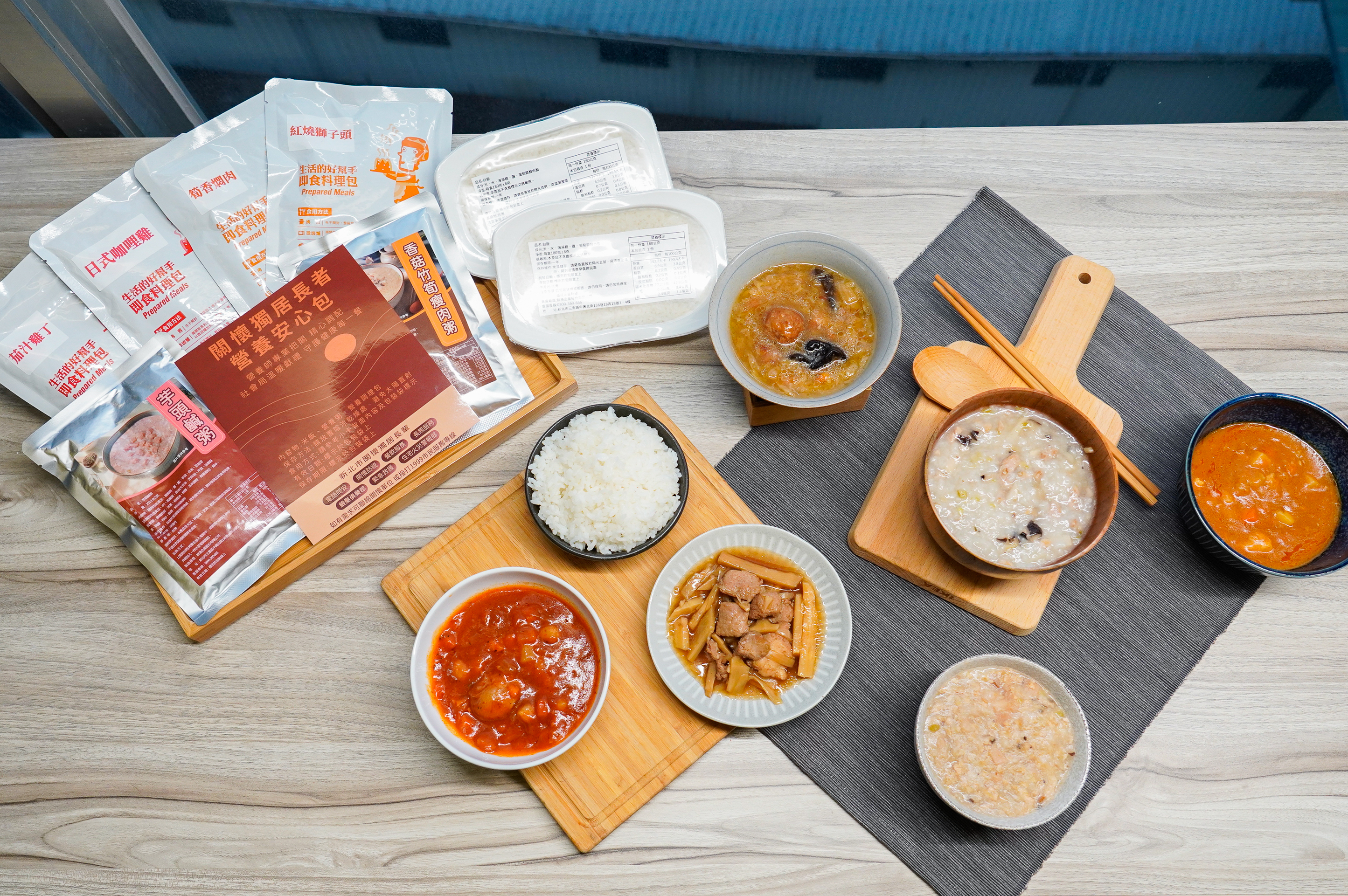  「關懷獨居長者營養安心包」內含筍香燜肉、日式咖哩雞、紅燒獅子頭、茄汁雞丁四款美味調理包及芋頭鹹粥、香菇竹筍瘦肉粥和2盒白飯