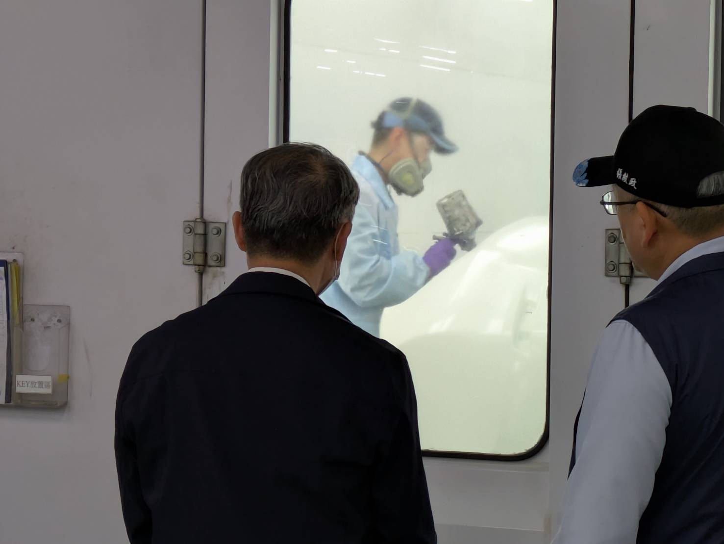 國都汽修廠廠長張紋政向陳瑞嘉局長介紹烤漆作業。