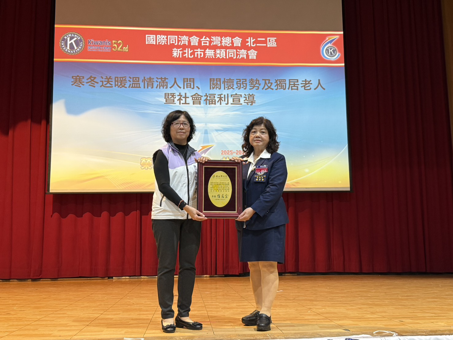 新北社會局許秀能副局長（左）代表致贈感謝牌予無類同濟會會長賴秀華（右）
