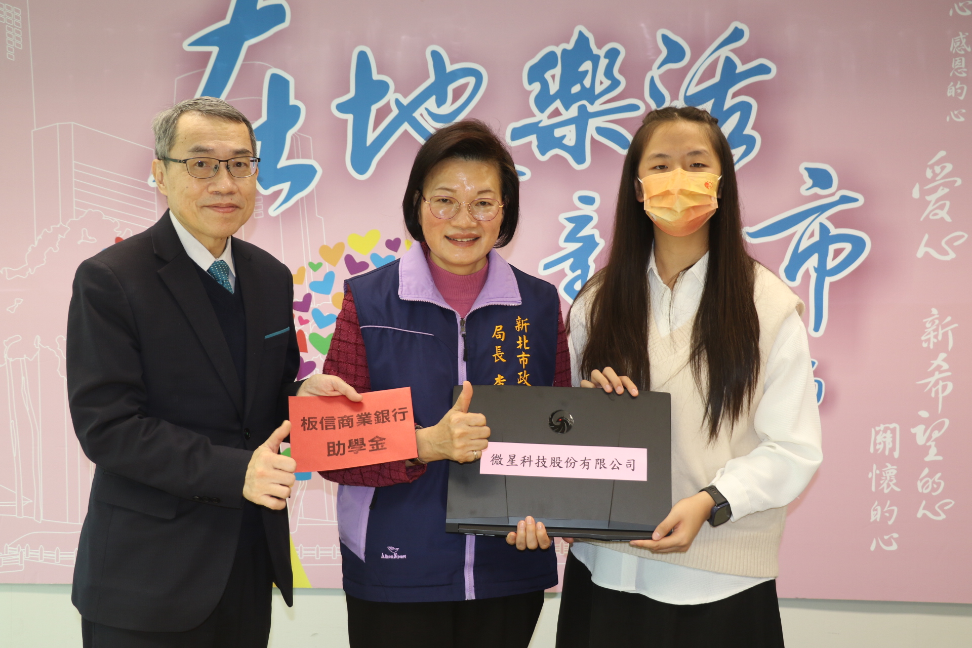 板信銀行副總經理黃家泰（左）捐贈助學金，李美珍局長代表微星科技捐贈筆電給小亭。