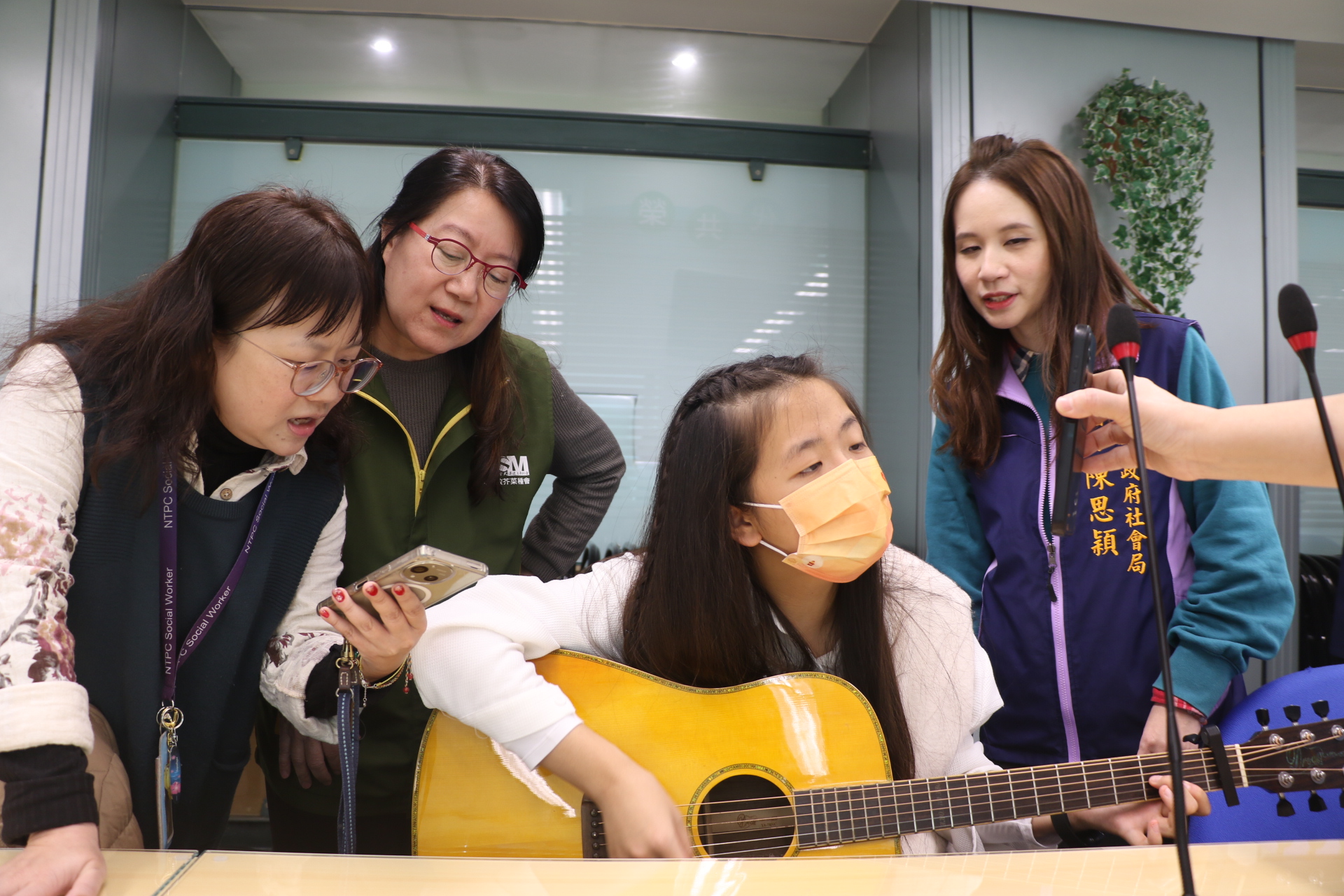  小亭自彈自唱五月天的「知足」和「突然好想你」，希望藉由歌聲表達對所有幫助過的人的感謝。左2為安置機構院長蘇鈺惠。