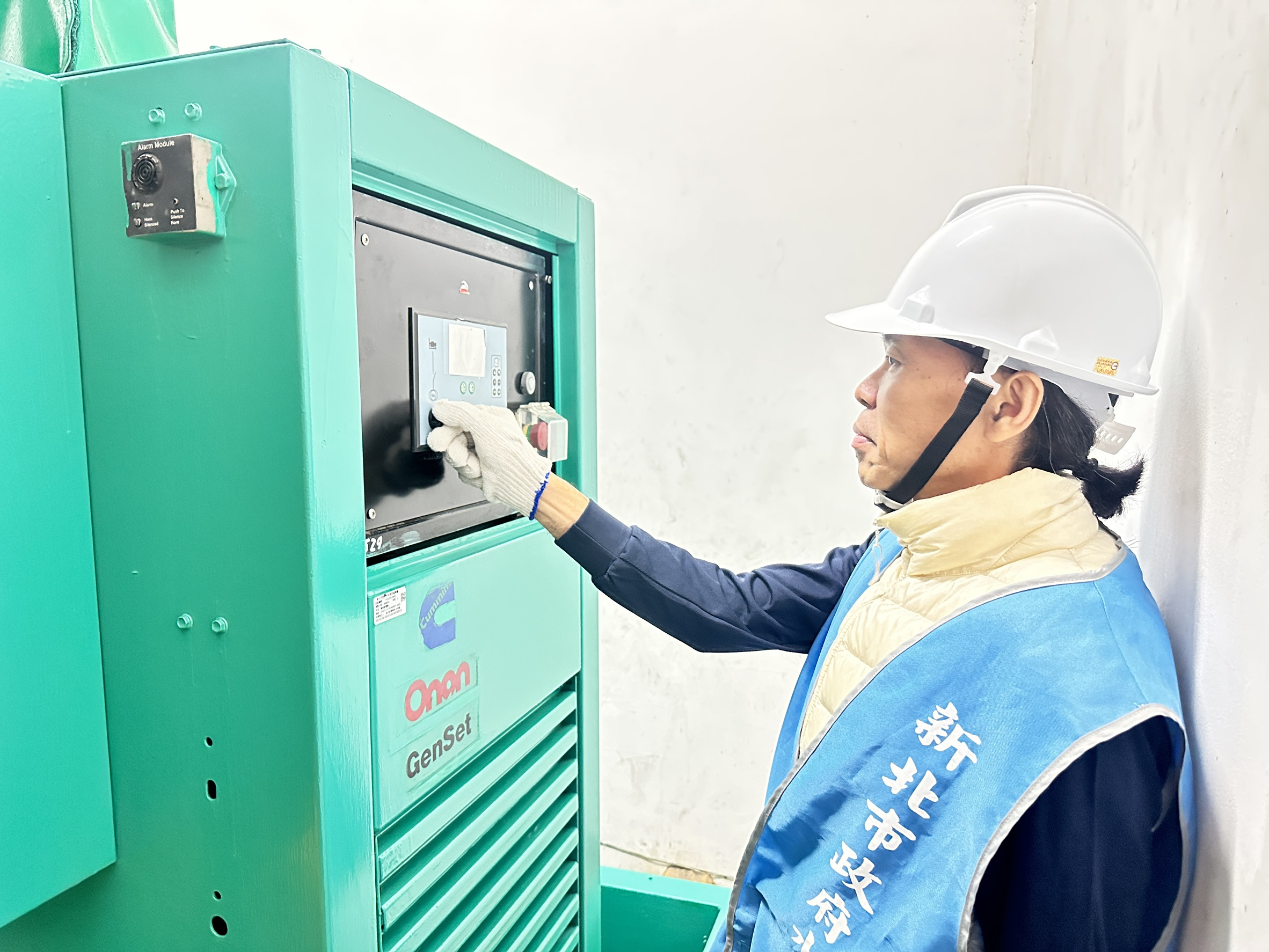 抽水站人員操作抽水機的控制盤，以啟動機組