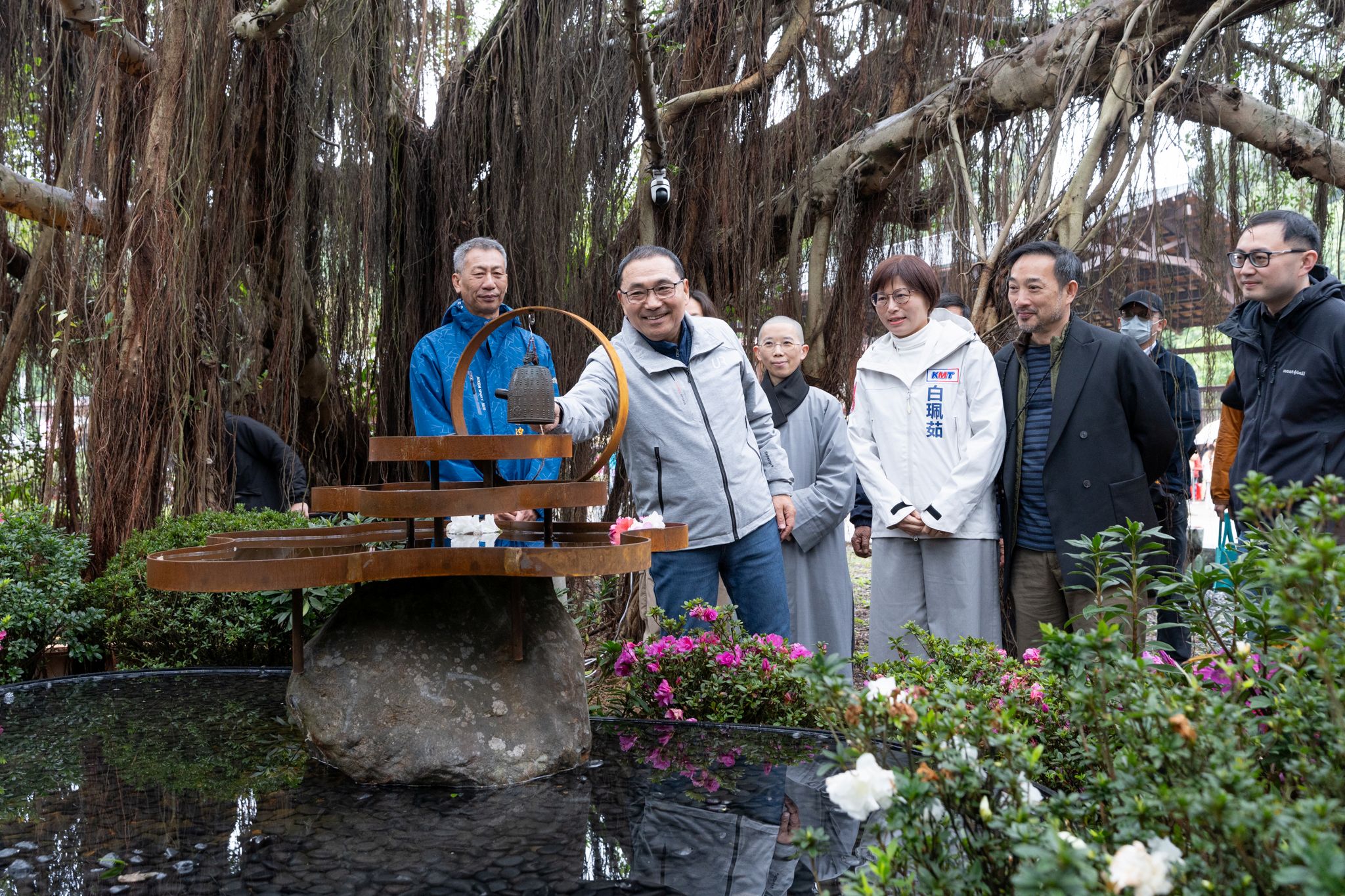 藝術家王煦中與法鼓山合作打造杜鵑花藝「心花開」，作品懸掛來自法鼓山園區的法華鐘復刻迷你版，周圍徜徉柔美杜鵑花，邀請民眾假期前來賞花祈福