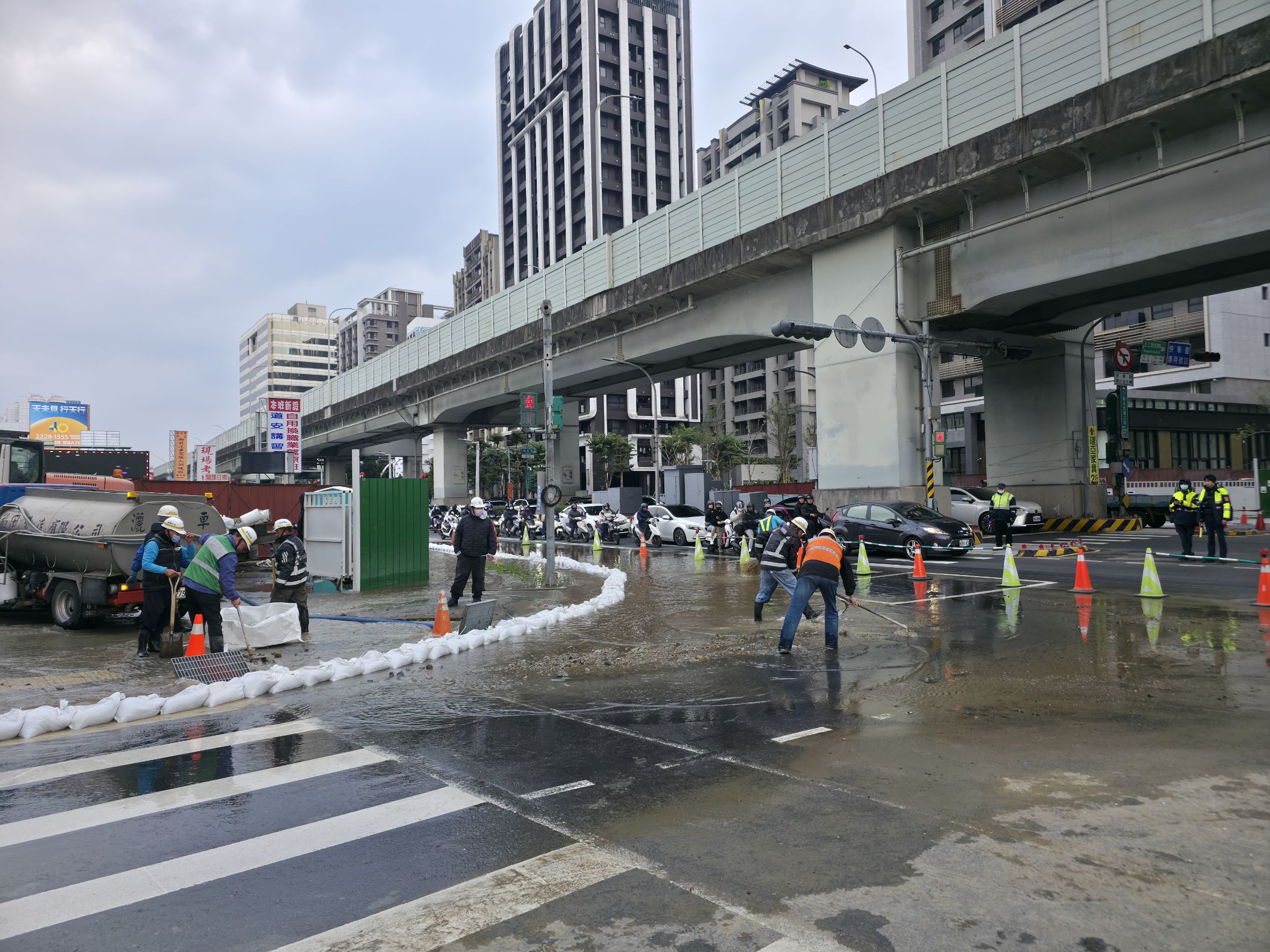 施工廠商堆置沙包以防水流外溢，減少車輛通行的影響。