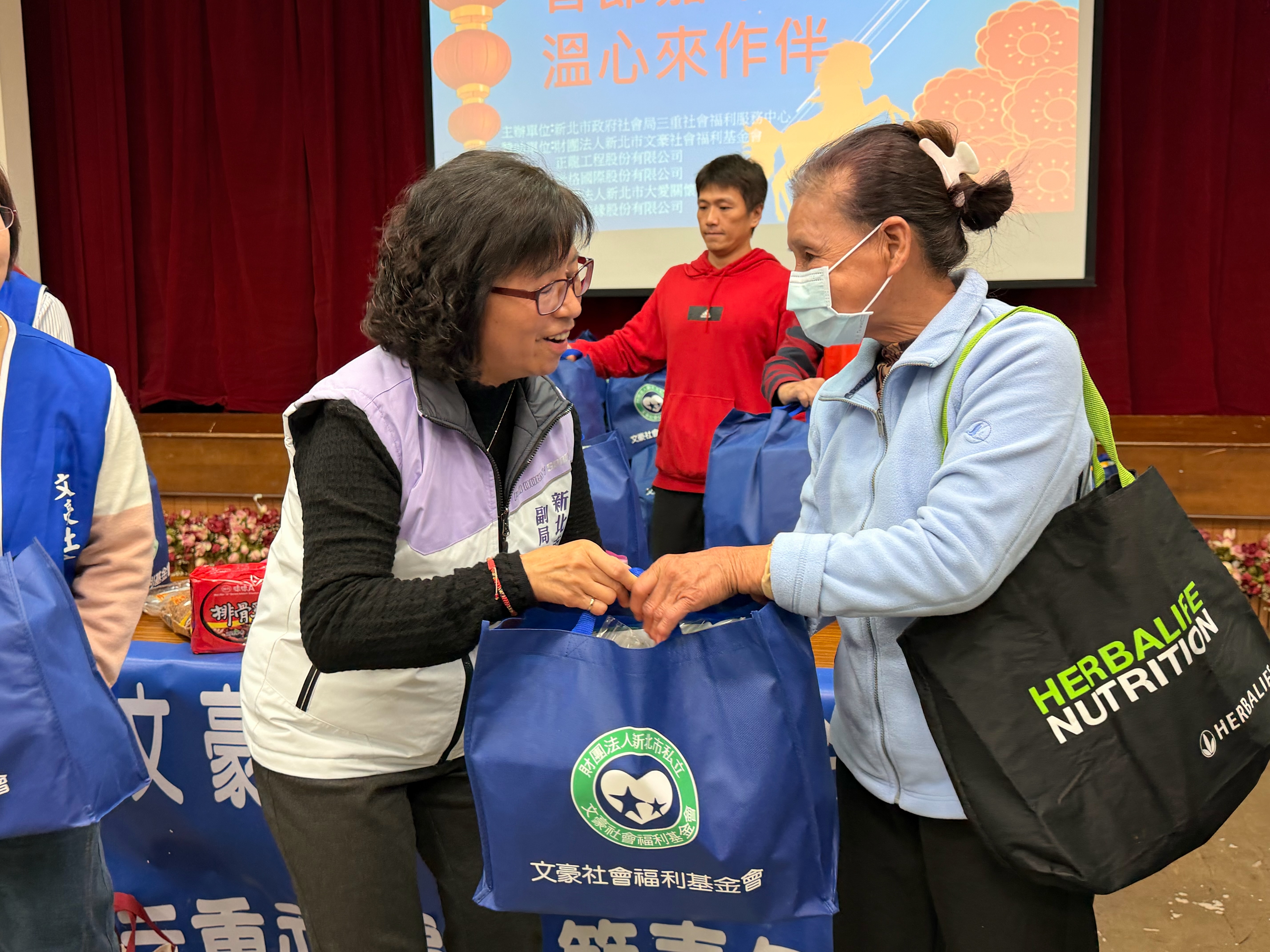 新北社會局副局長許秀能(左)發放物資關心家戶