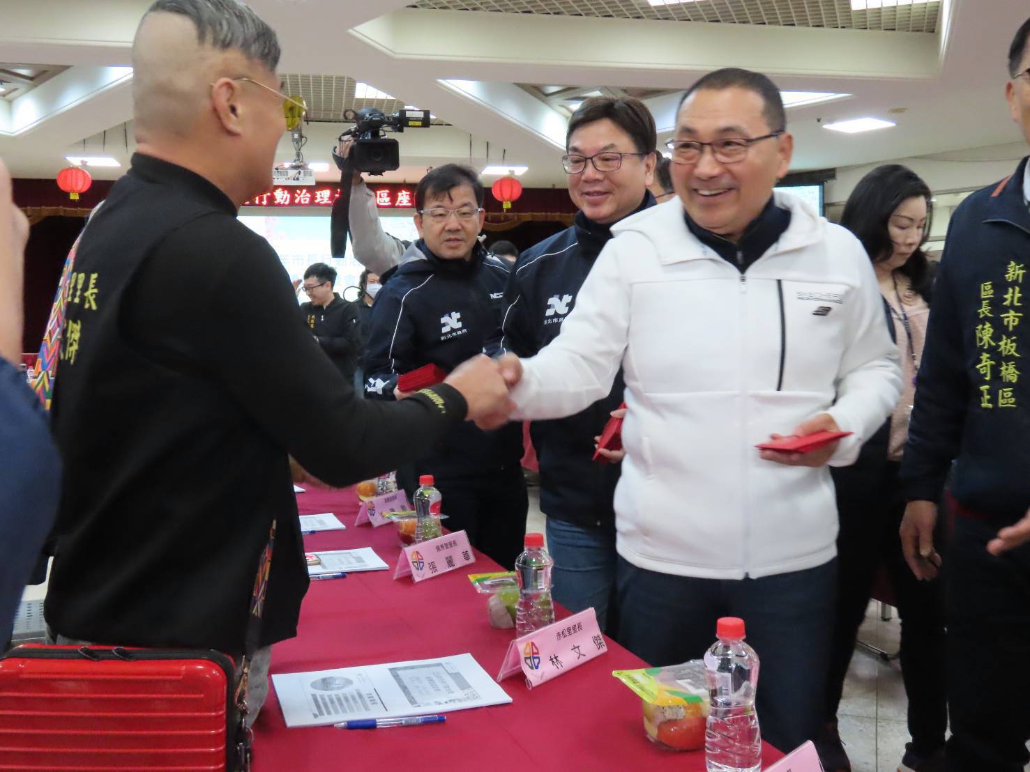 市長侯友宜與里長握手寒暄，同時贈予馬年福袋，祝福新春。