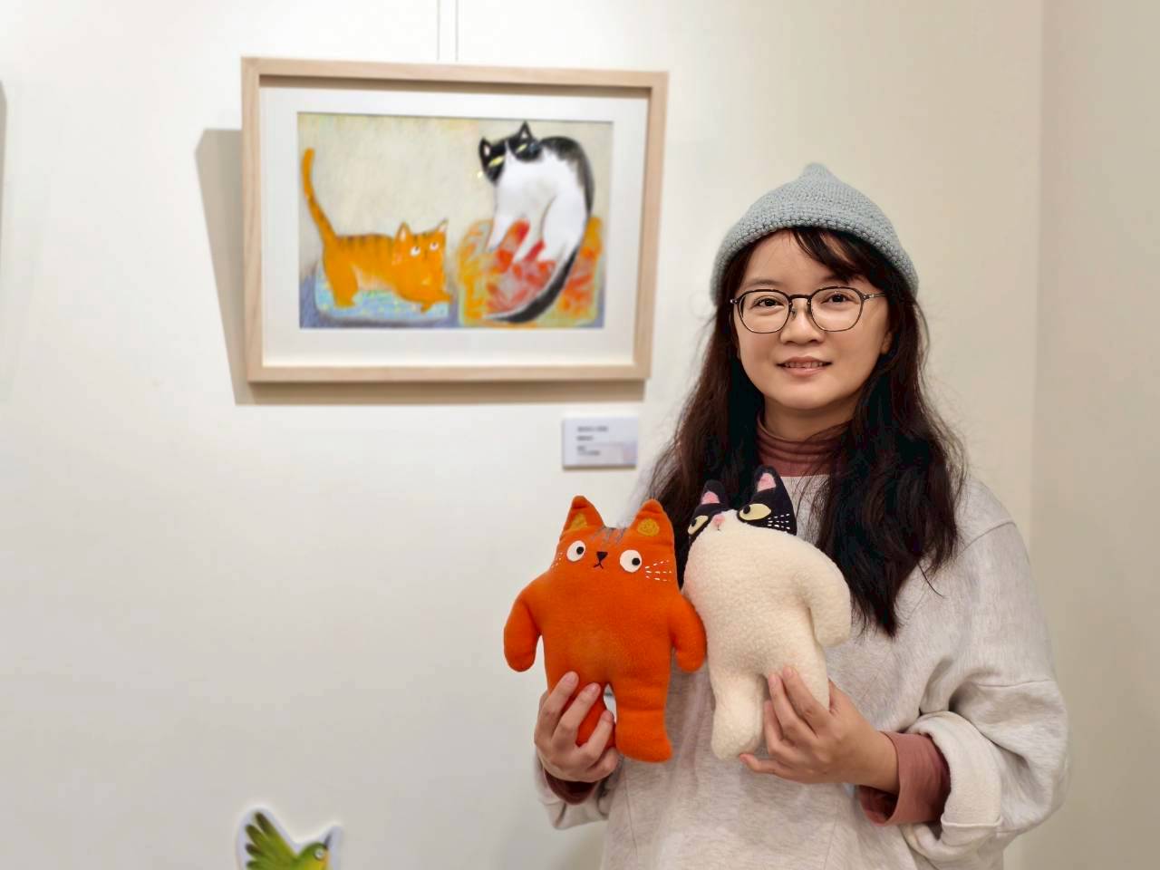 繪本作家葉曼玲與其新書《新來的小怪物》主角飯糰與橘子布偶合影。