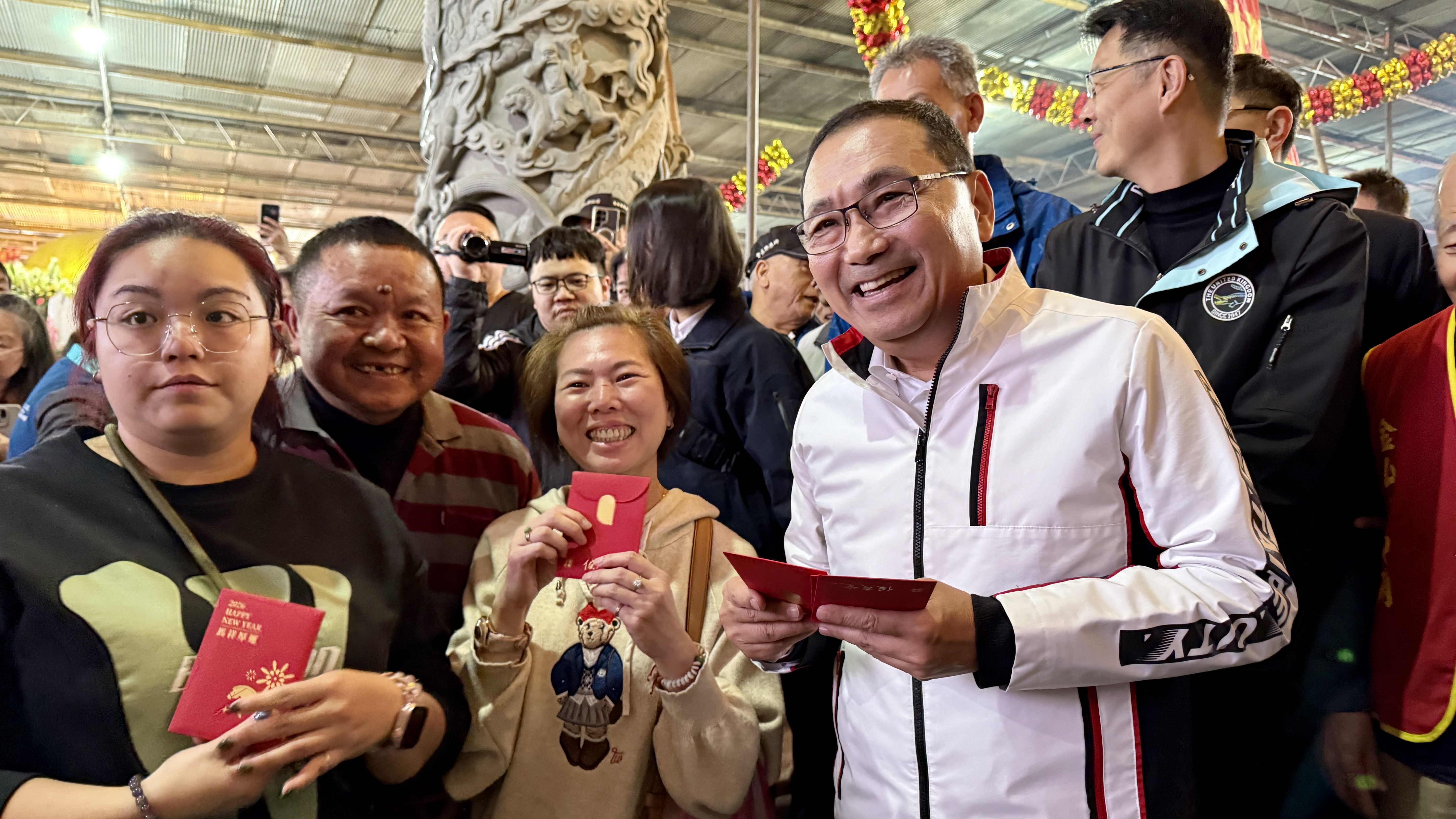 市長發放「馬上賺錢」福袋祝福大家財運到，並與熱情民眾合影。