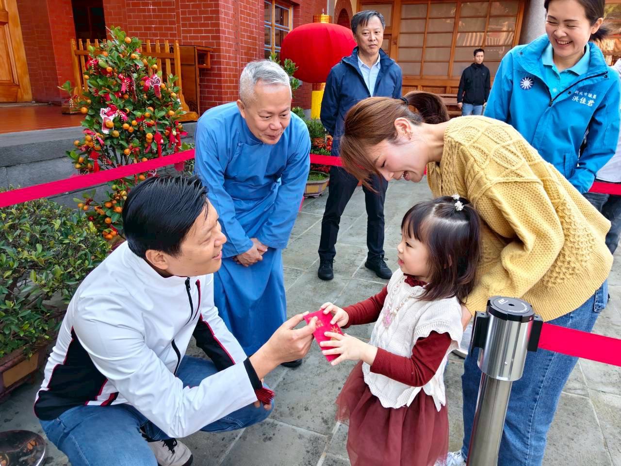 今日副市長朱惕之至三峽行修宮參香發福袋，給予小朋友祝福。