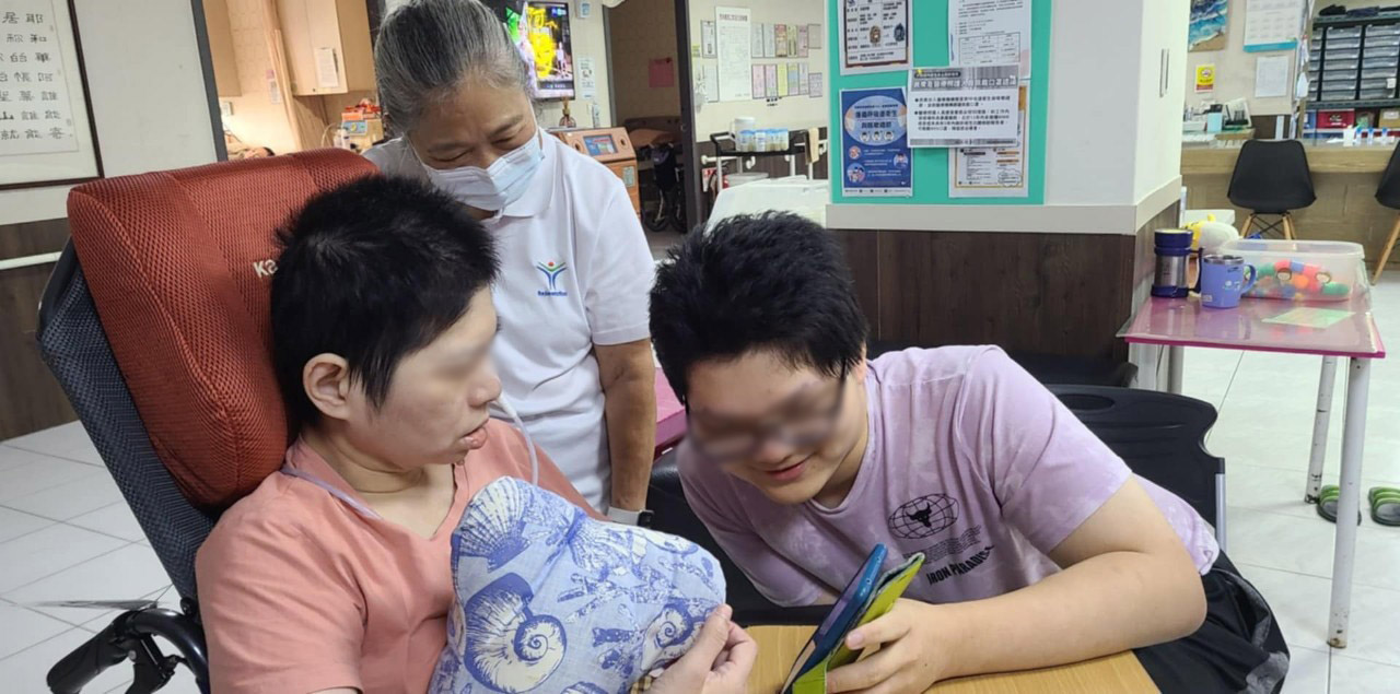  阿宏（右）將手機移近給母親（左）看弟弟小瑞的近況