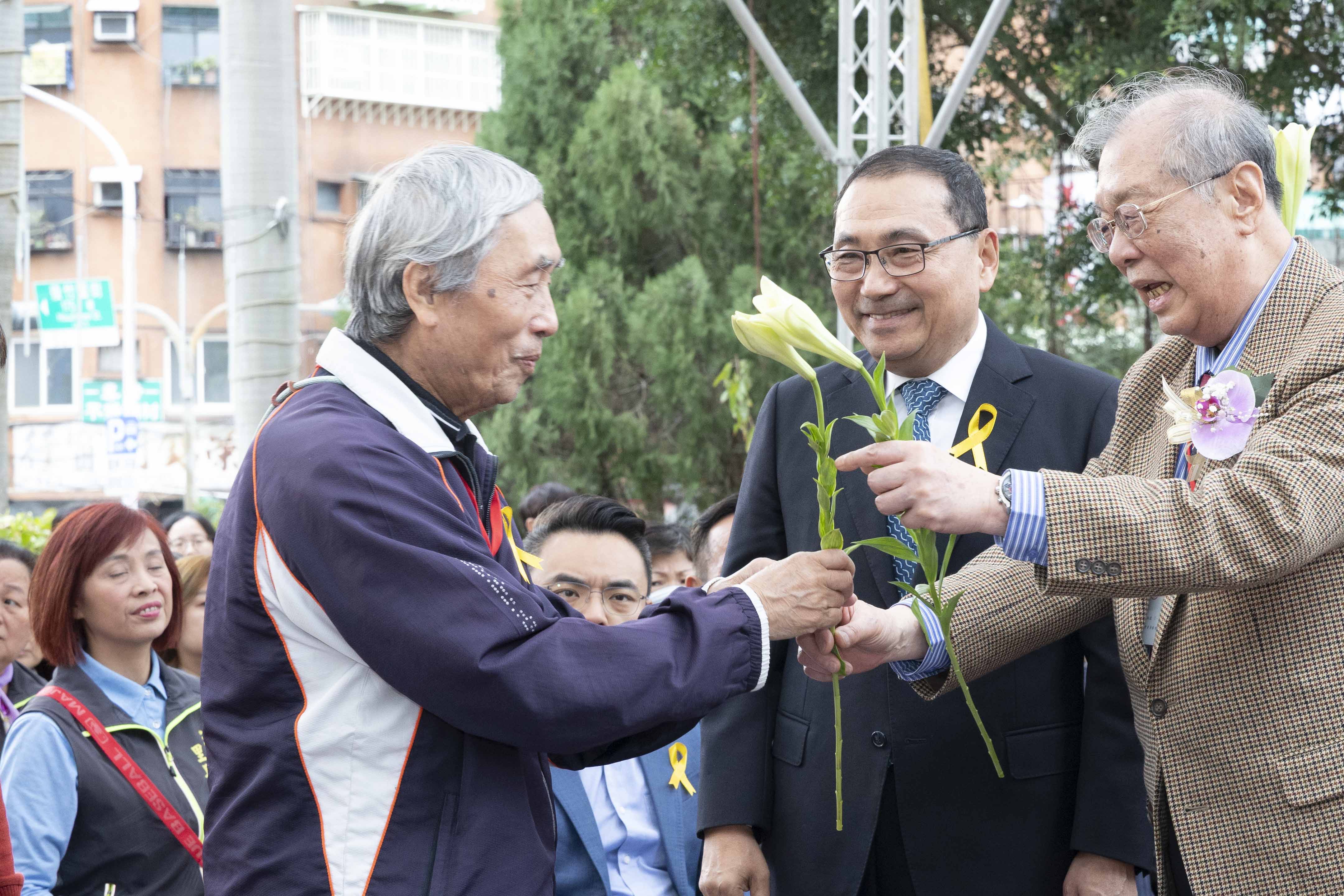 市長逐一遞送鐵炮百合給受難者家屬獻花，撫慰受難者心靈