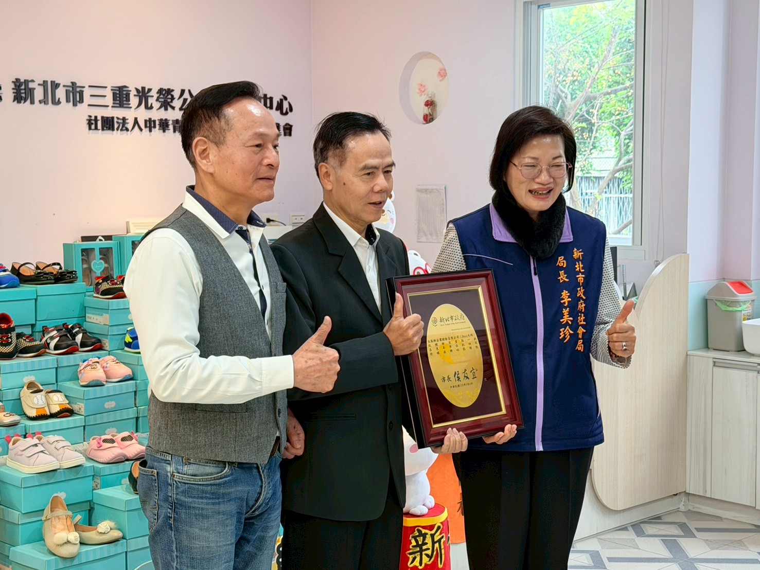  社會局長李美珍代表侯友宜市長回贈感謝牌給美萬新企業總經理王秋鴻（中） 左為居間媒合的李余典議員