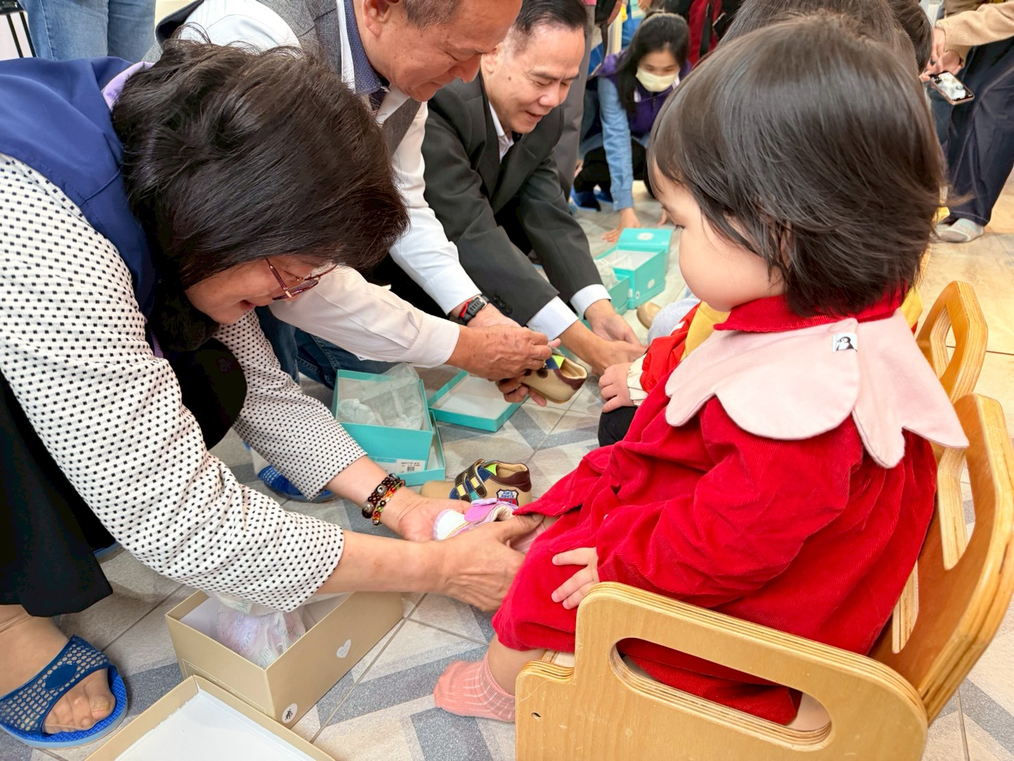  李美珍局長等人幫幼兒穿上新鞋
