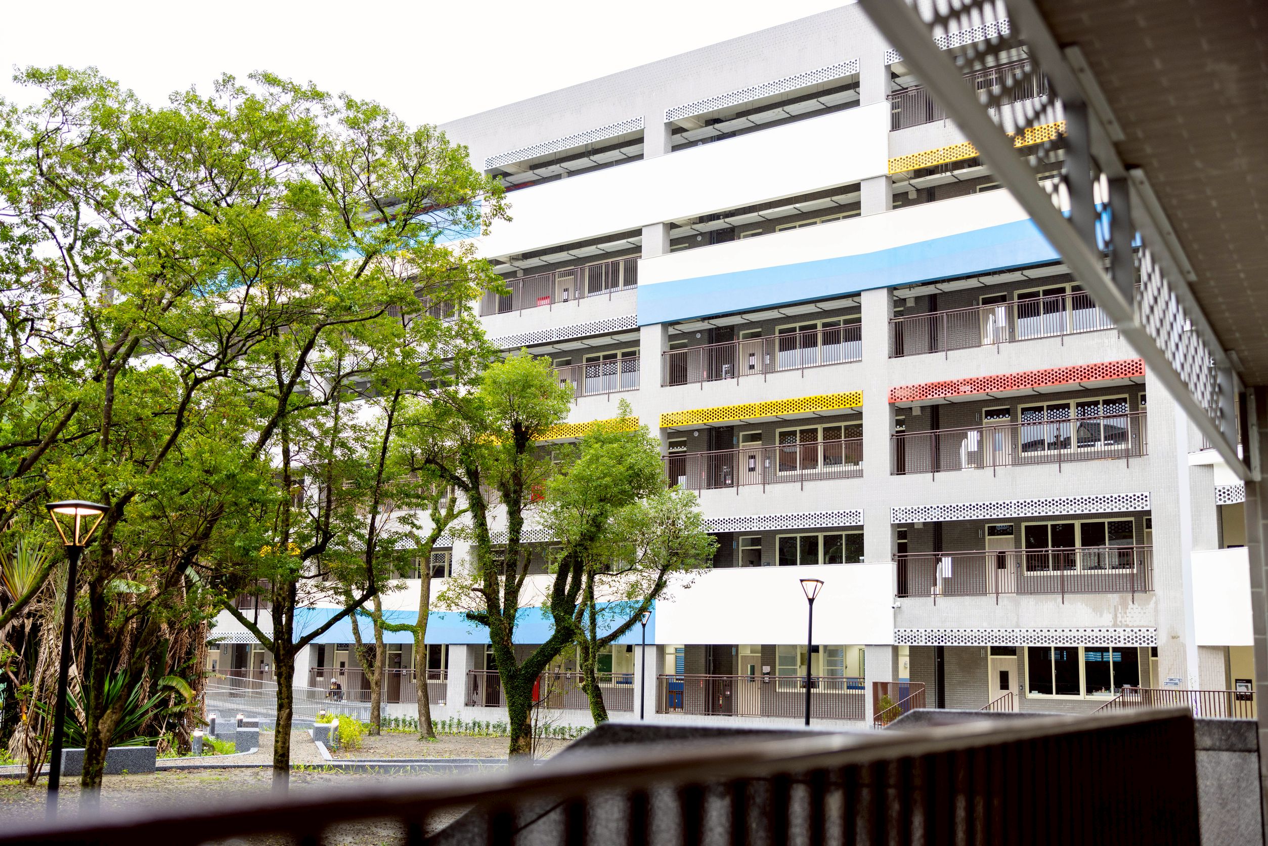 秀峰高中新校舍採淺灰色系，搭配鮮豔烤漆金屬板點綴，呈現煥然一新的校園風貌。