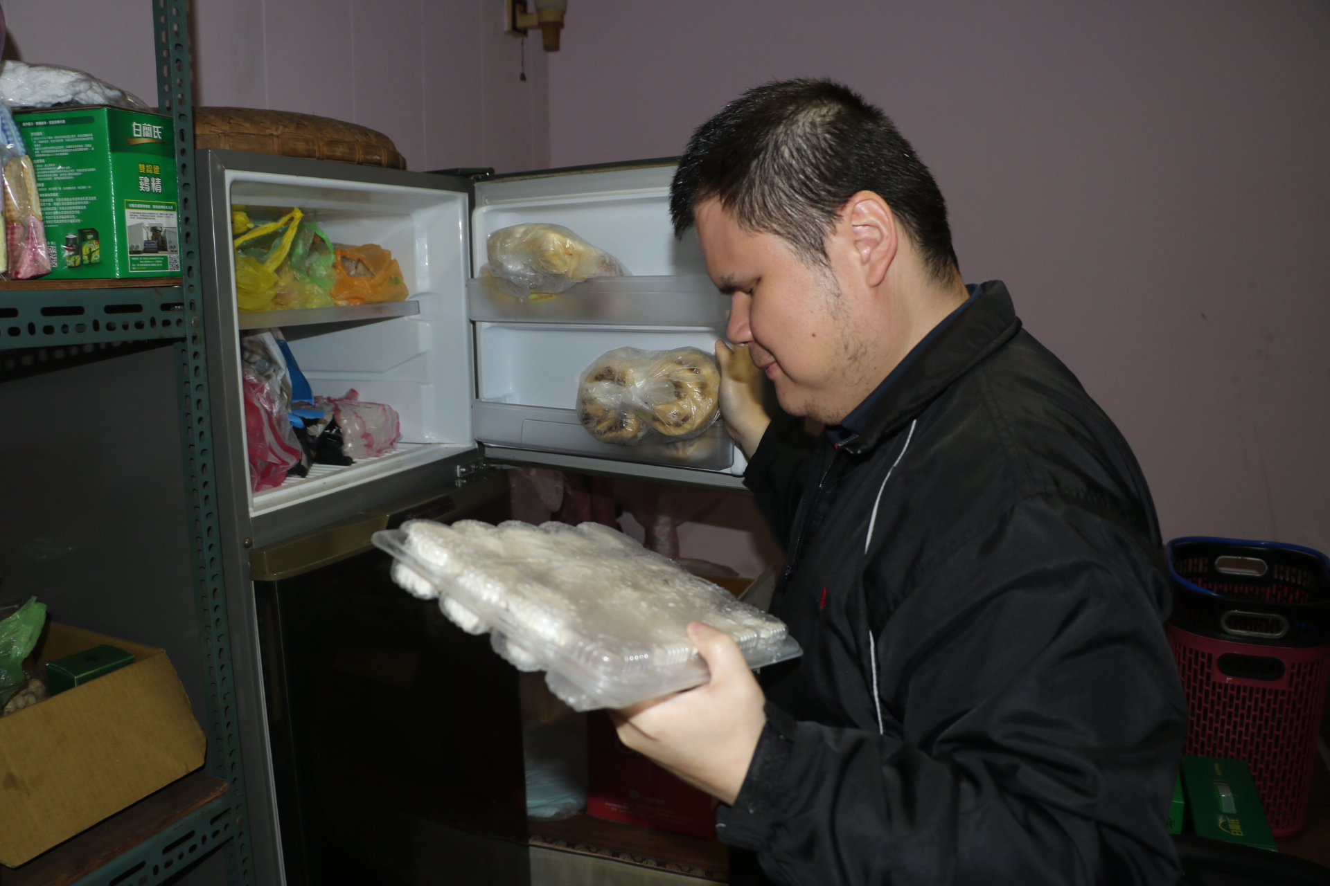  先天視障者呂坤諭在樂明中心生活自理老師訓練下 熟練地從冰箱取出冷凍水餃 準備用電鍋烹煮