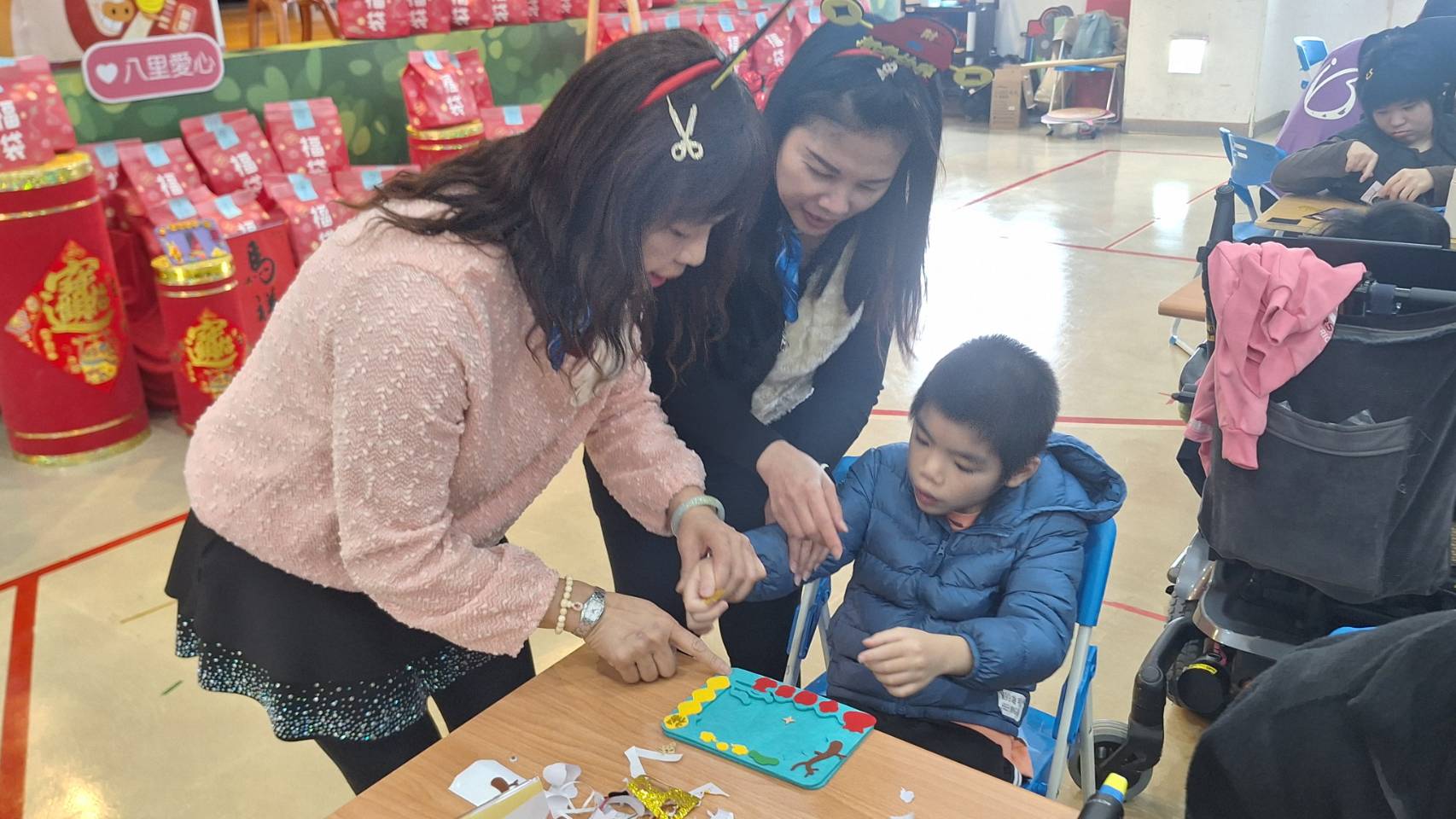 院生阿忠(右)和志工惠真(左1)與秋香(中)一起創作相框DIY