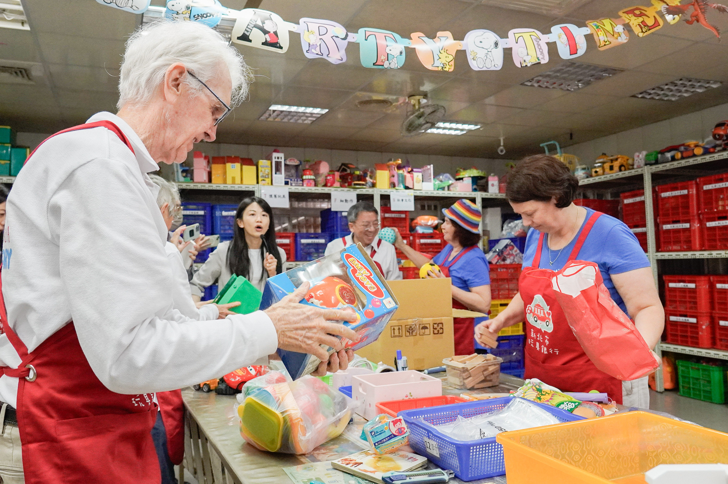  澳洲參訪團穿起玩具銀行紅色的志工服，一起體驗回收、分類和整理。