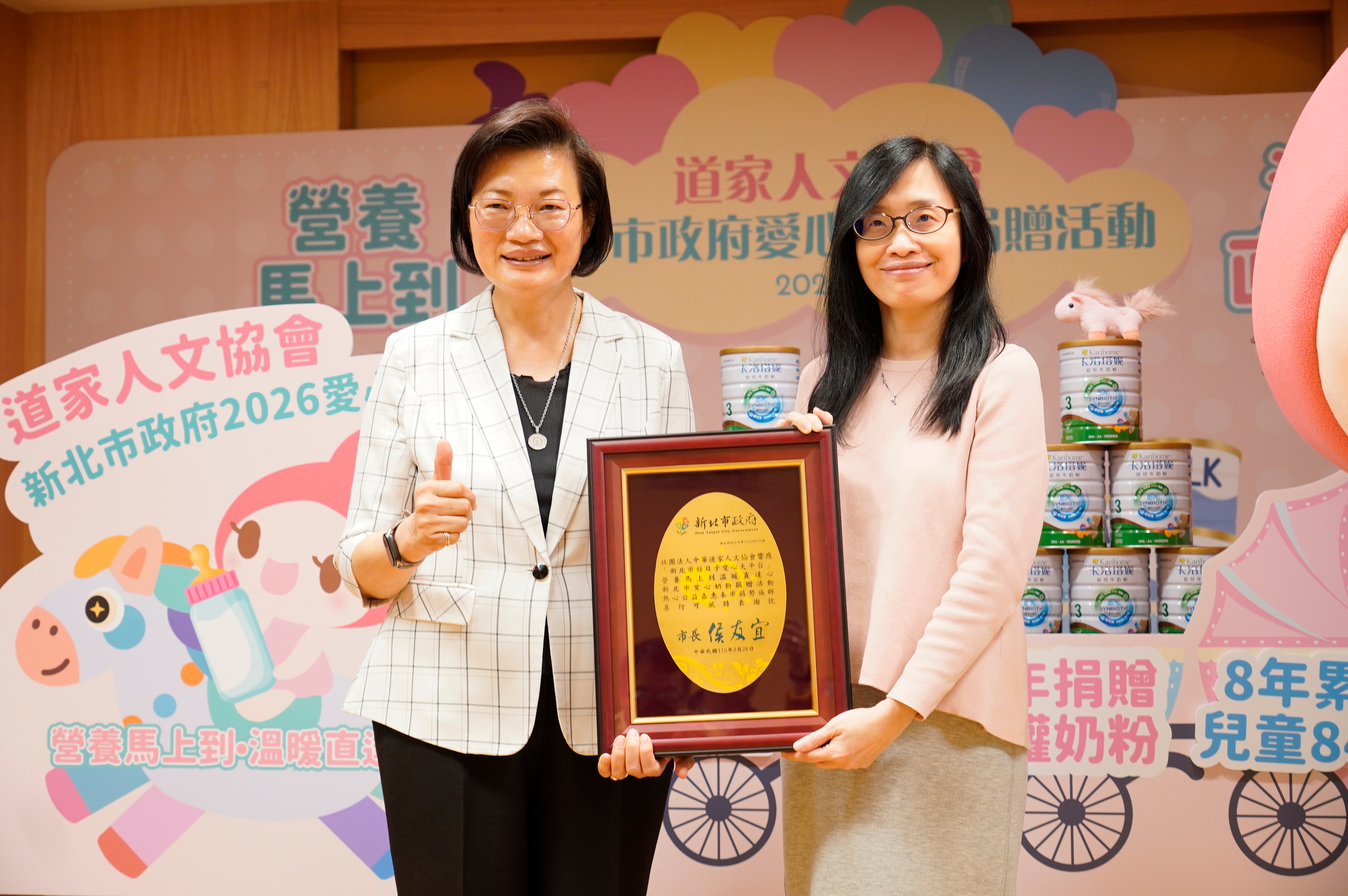 社會局長李美珍代表代表侯友宜市長回贈感謝牌給中華道家人文協會理事長張旖（右）