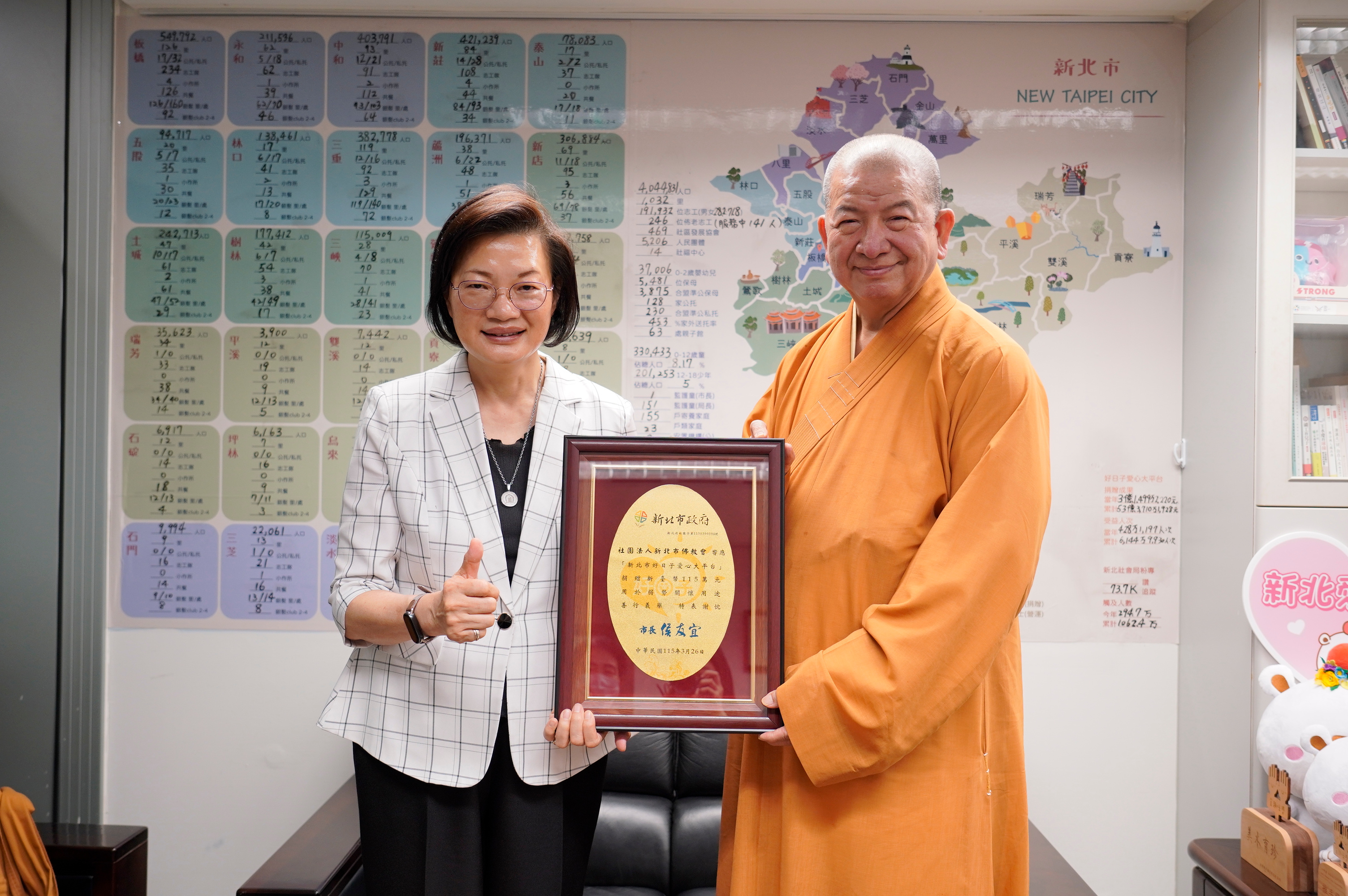 社會局長李美珍代表代表侯友宜市長回贈感謝牌給釋明光法師.