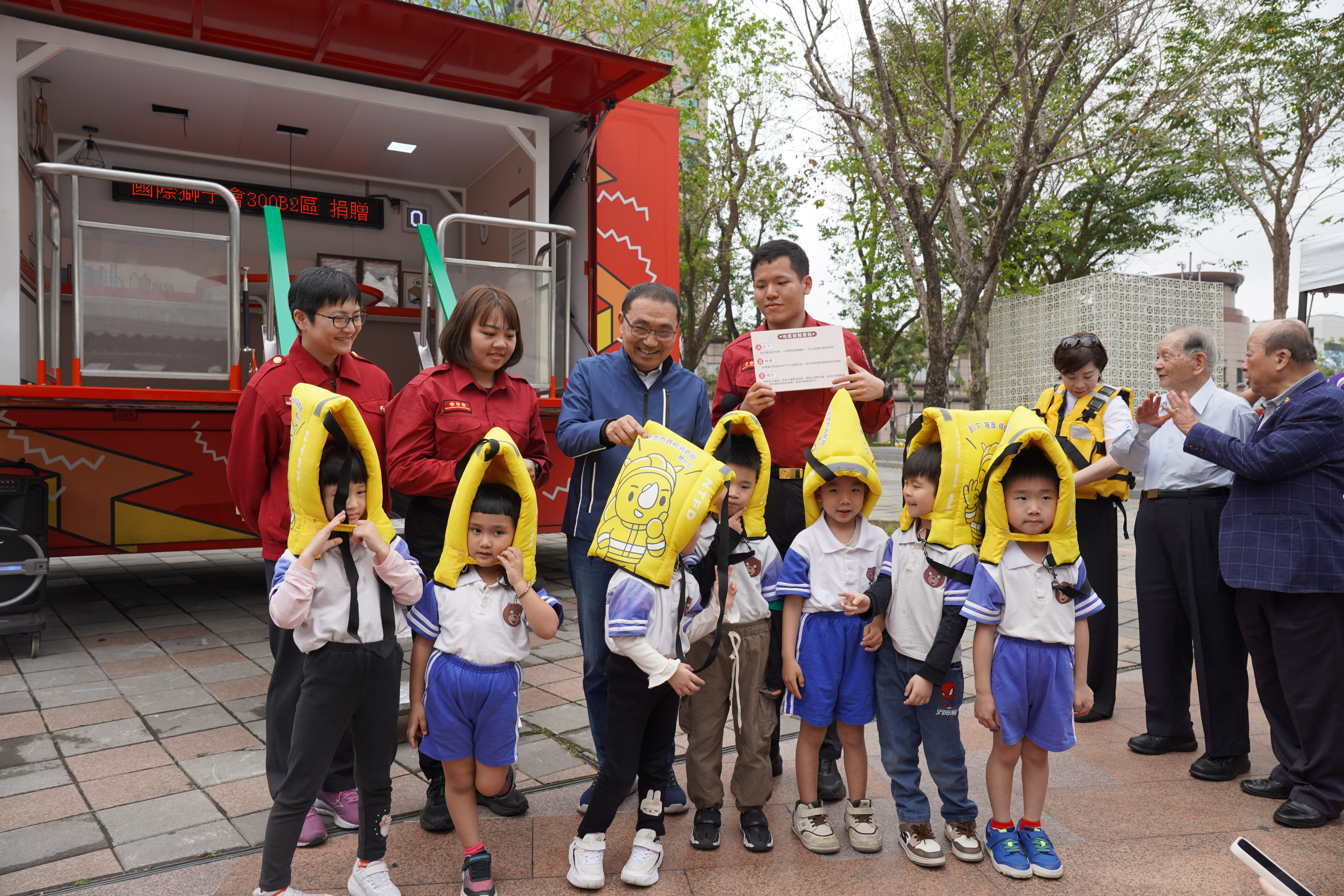  侯友宜市長幫小朋友調整地震保護頭套.