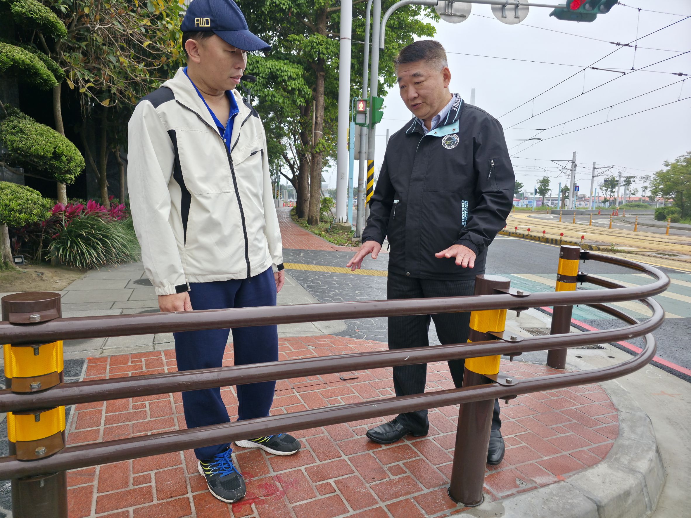 工務局長馮兆麟(右)與養工處長鄭立輝實地訪視淡水區中正路二段51巷人行道拓寬及設置景觀欄杆的成果，提供寬敞安全人行環境。