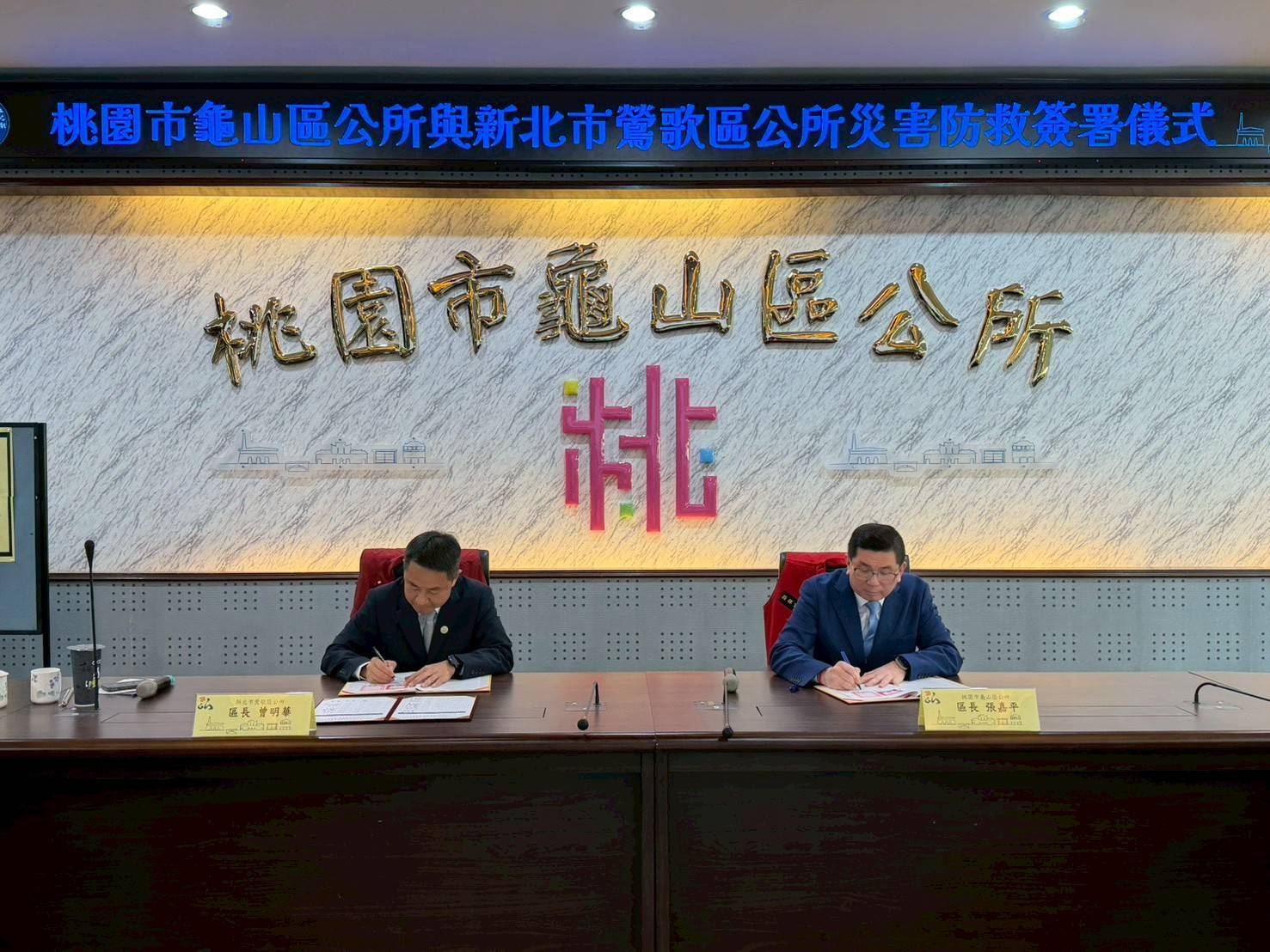 鶯歌區長曾明華(左)及龜山區長張嘉平(右)簽署