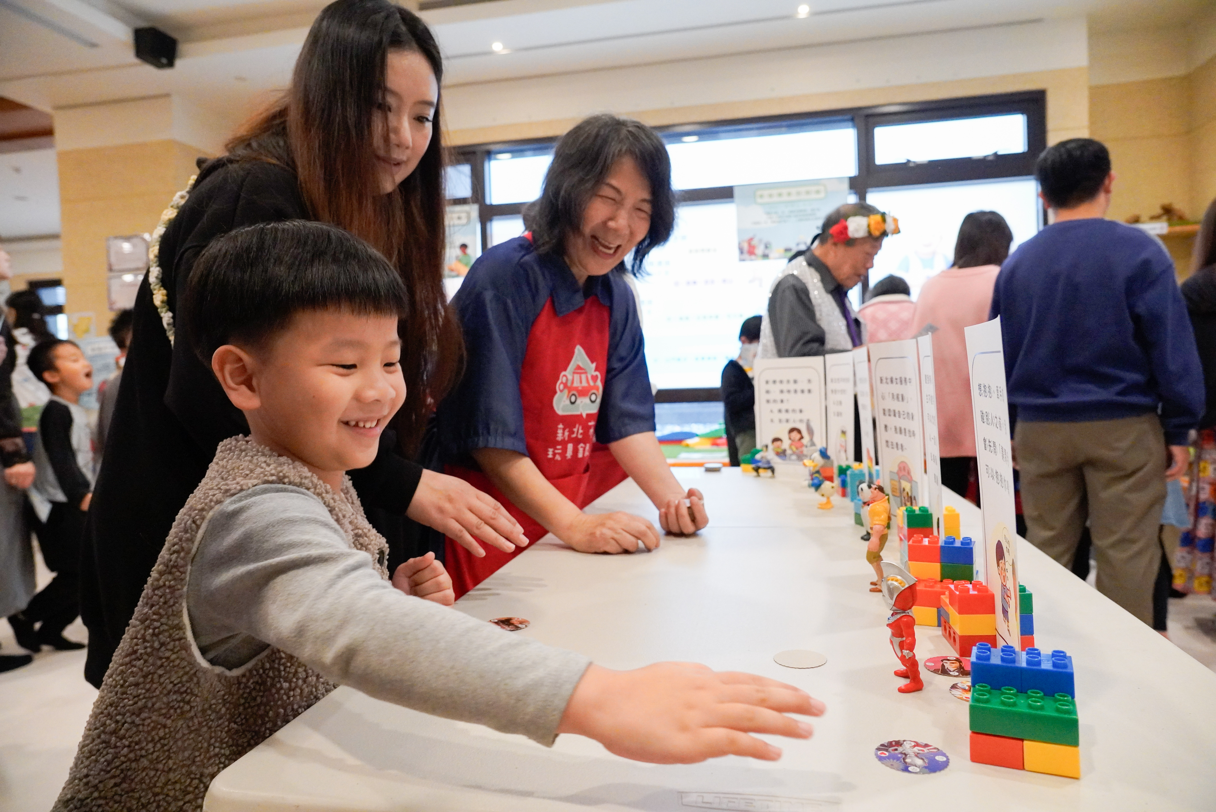 家長帶小朋友玩尪仔標遊戲，蘊含家務分工和性別平等觀念。