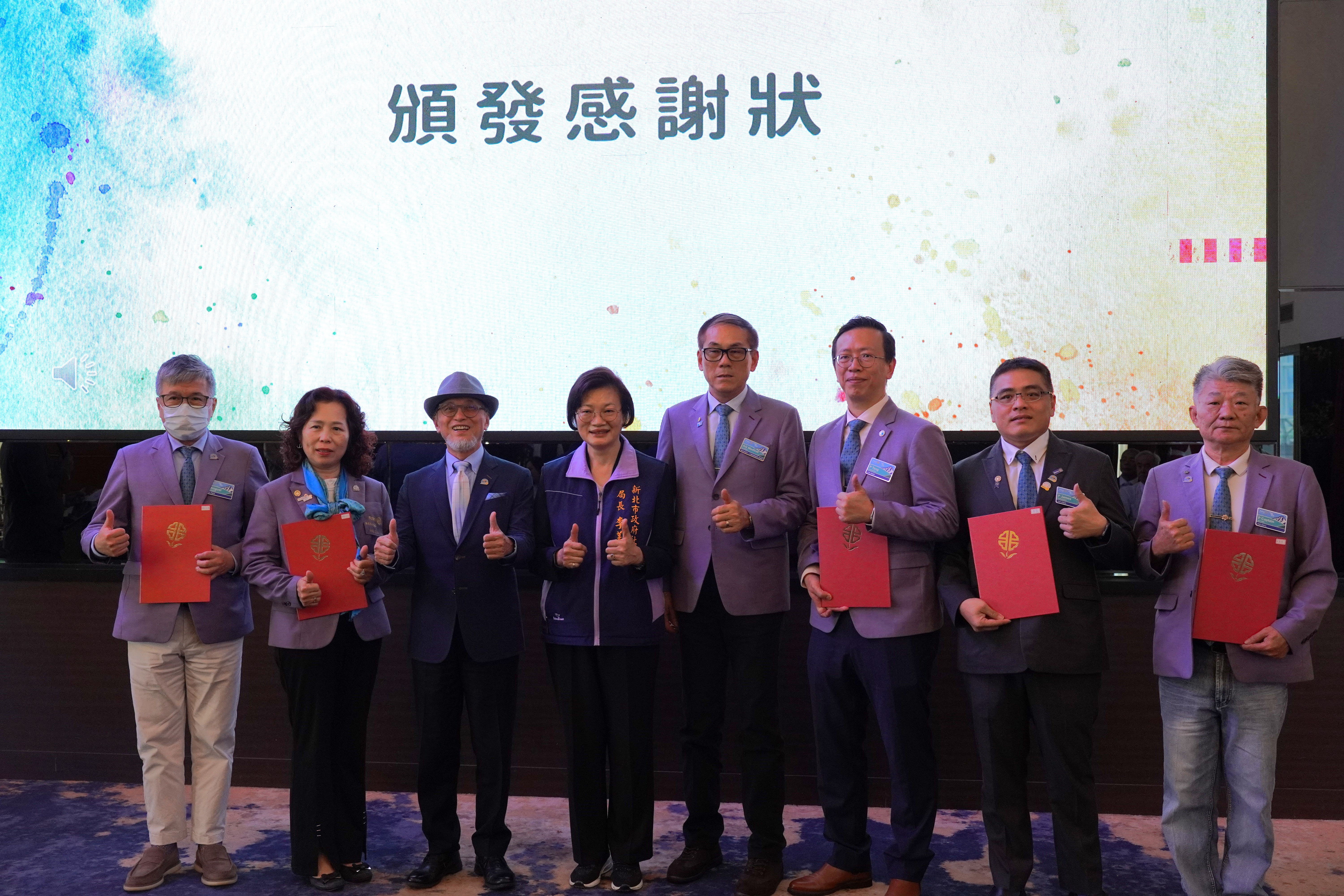 社會局長李美珍代表侯友宜市長頒贈感謝狀給綠家扶輪社 左3為國際扶輪3490地區總監張煥章 右4為助理總監盧添富 右3為綠家扶輪社長陳塘偉