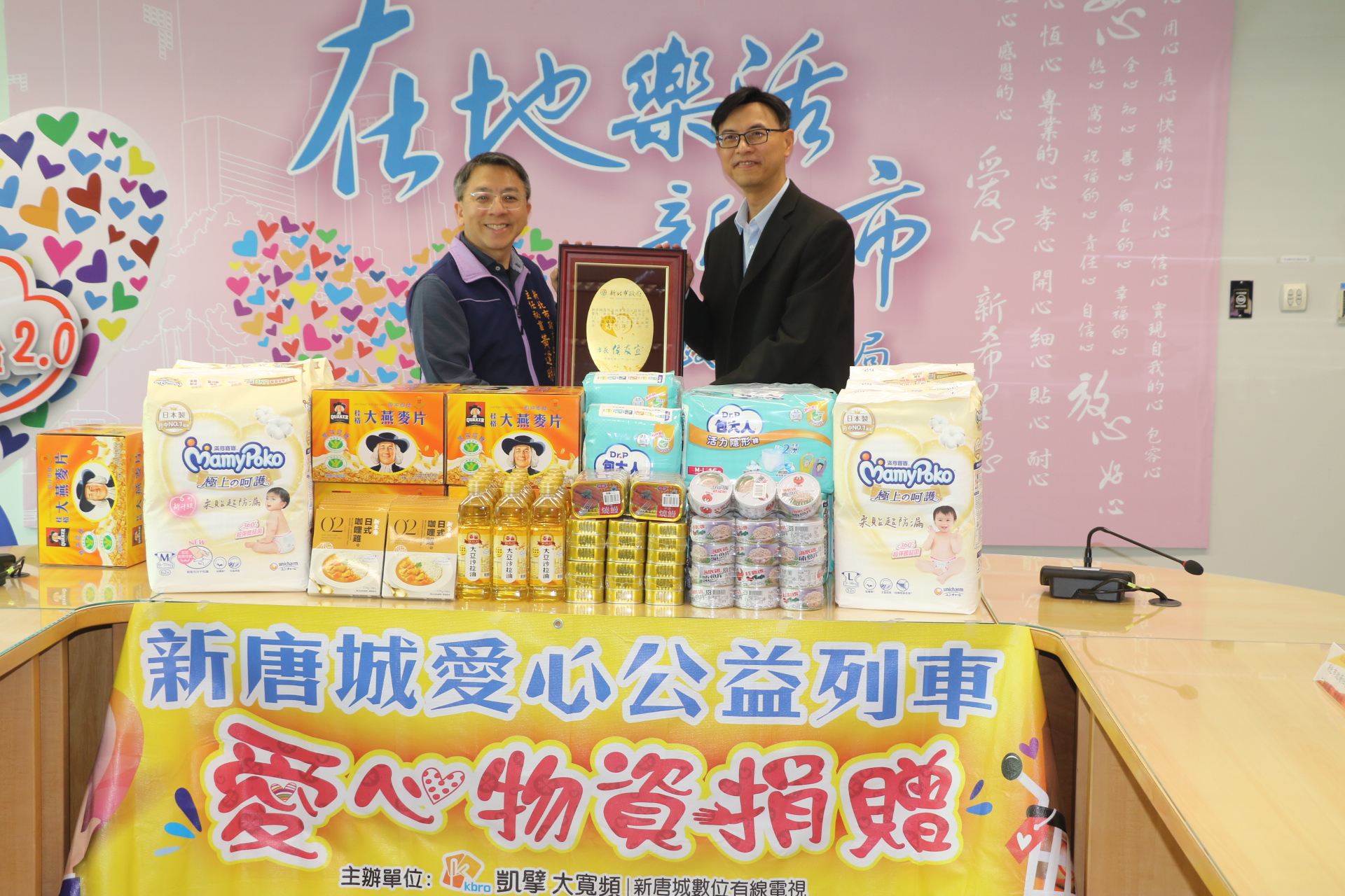 社會局主任秘書黃逢明代表侯友宜市長回贈感謝牌給新唐城有線電視總經理廖咸隆