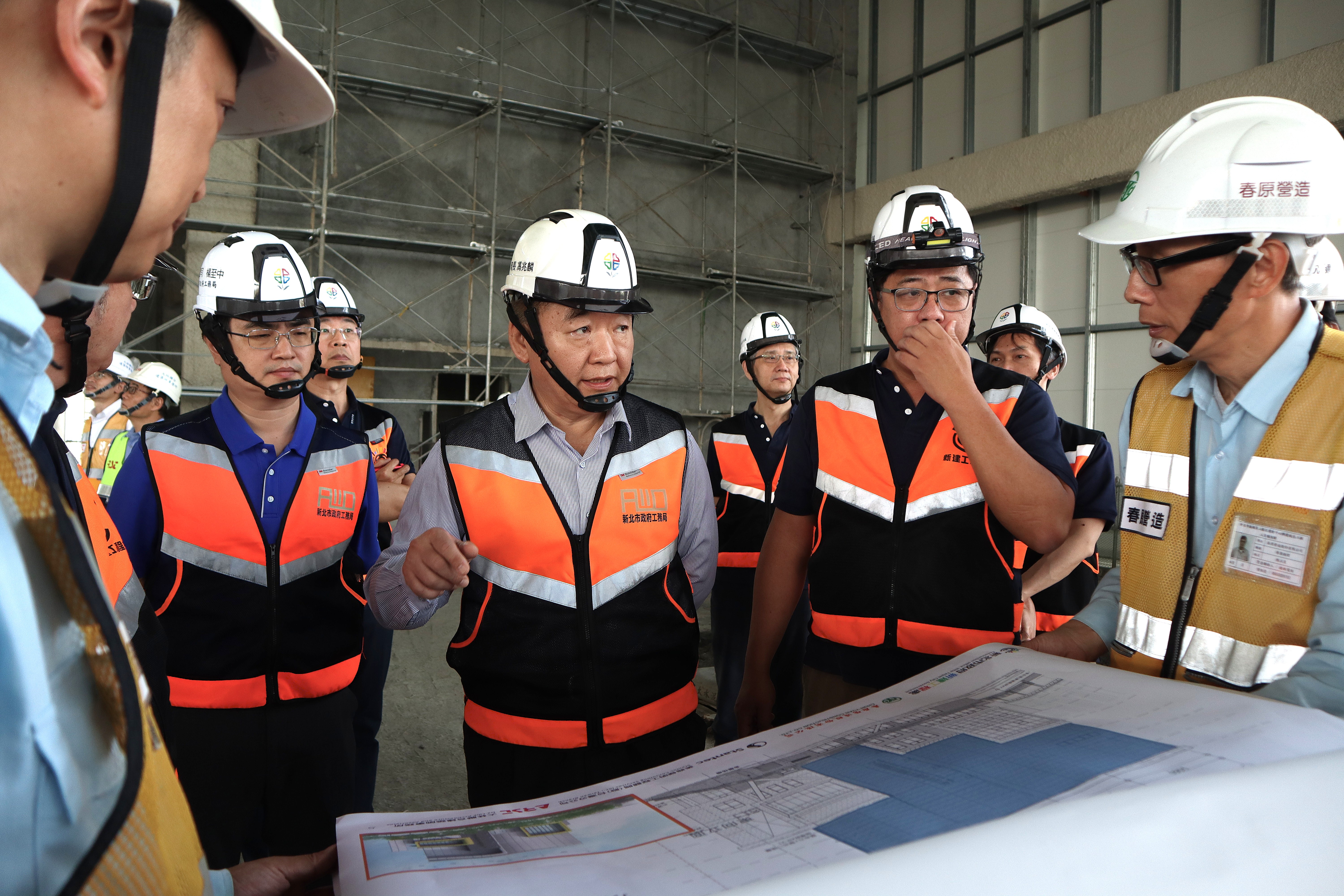 工務局長馮兆麟(右三)偕同總工程司楊至中(右四)等人，與廠商討論工程項目與施工進展。