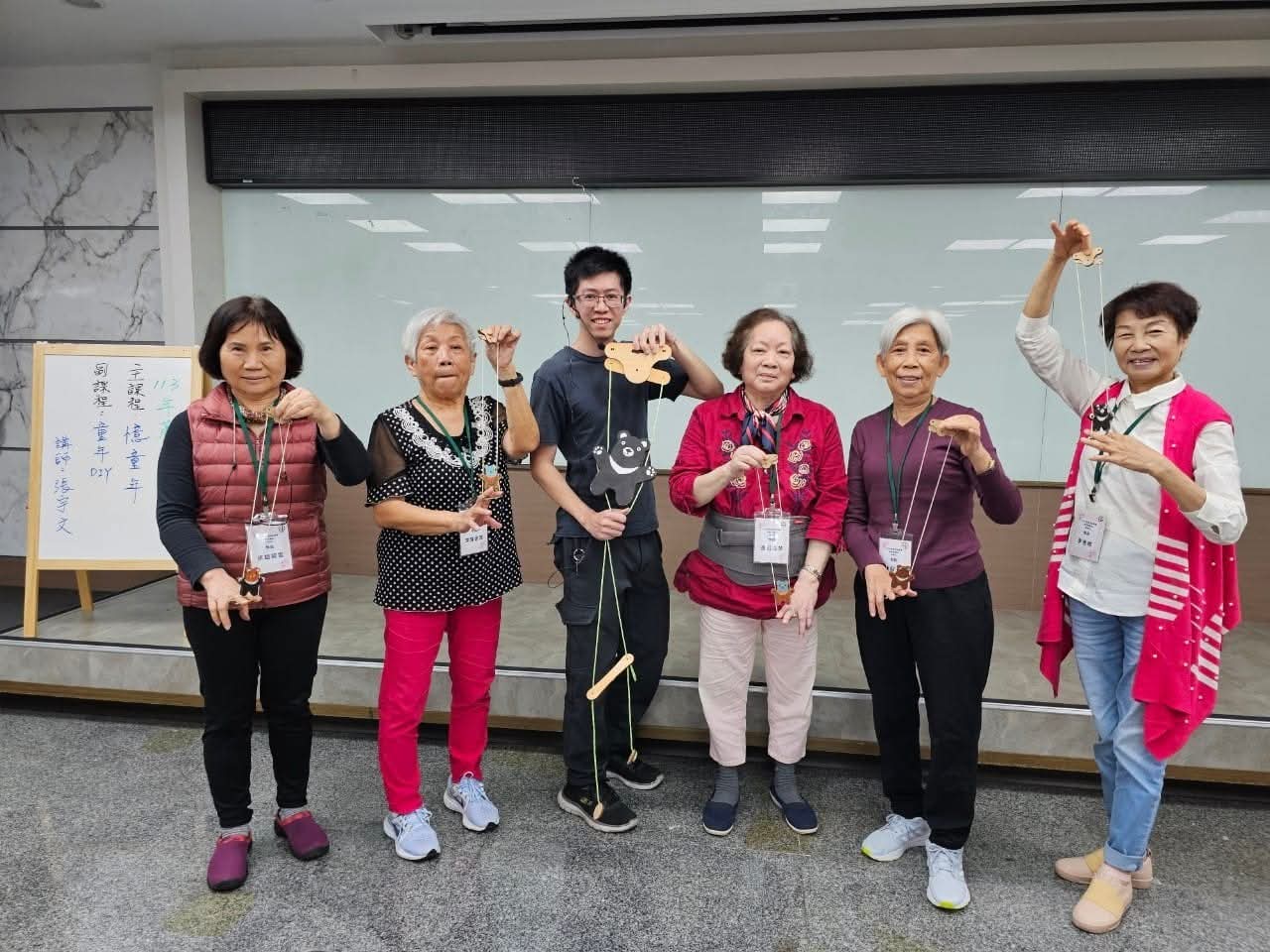 張宇文（左3）設計的「上升黑熊」玩具，不僅照顧關懷據點長輩愛玩，還受到僑委會和外交部的青睞。