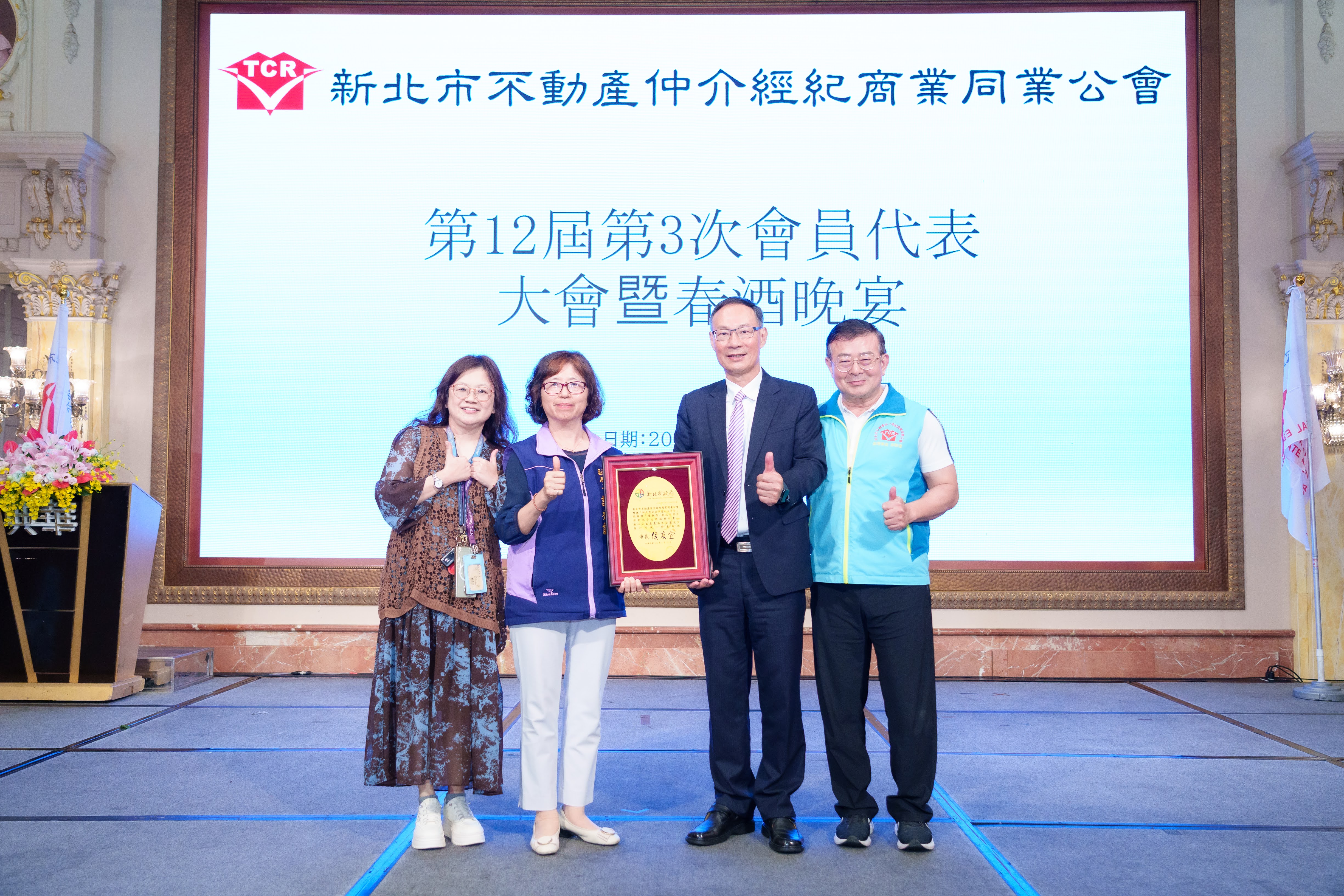  社會局副局長許秀能（左2）代表侯友宜市長回贈感謝牌給新北市不動產仲介經紀商業同業公會理事長林平川（右2）和副理事長孫啓達（右1）