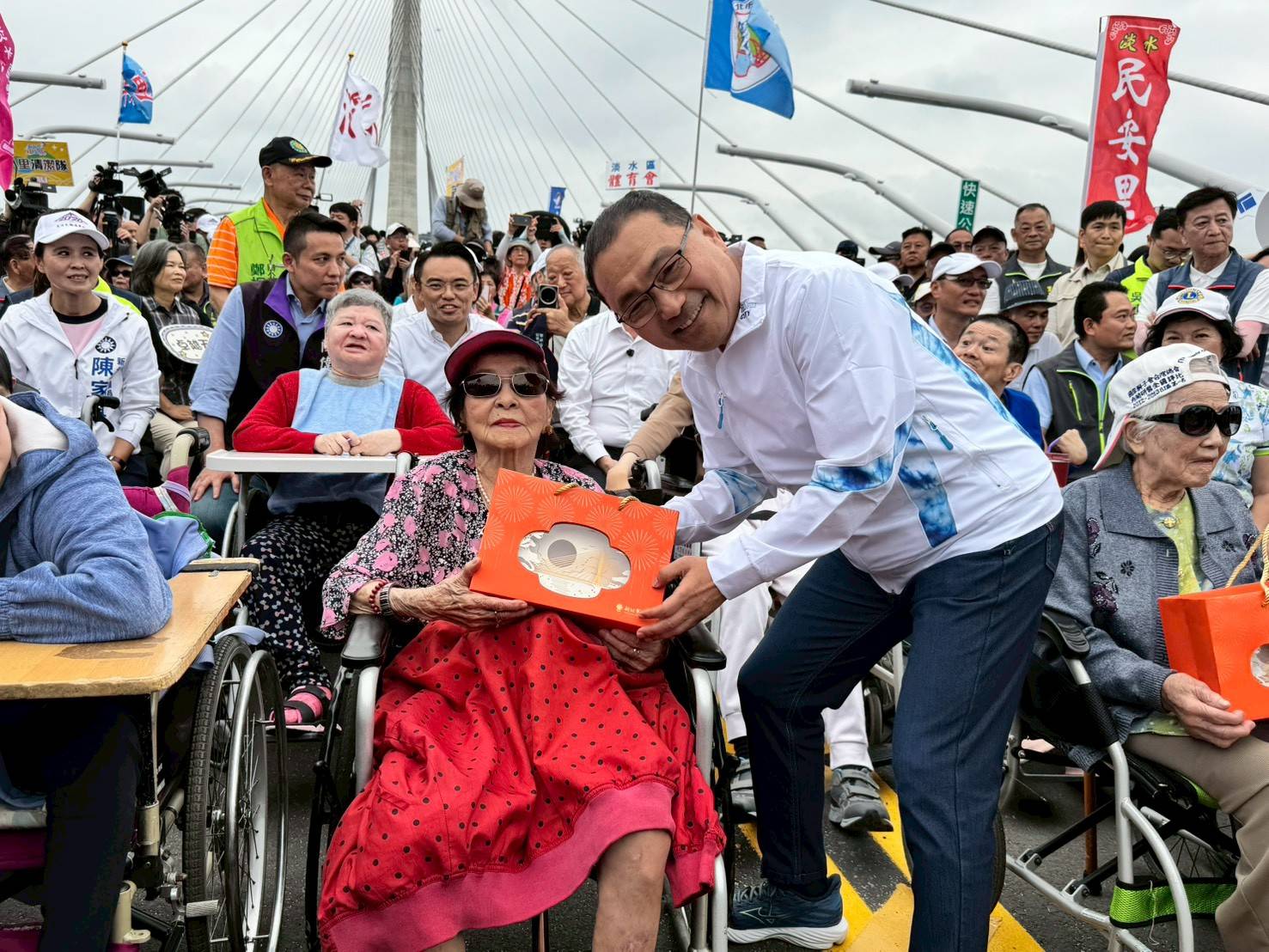 市長侯友宜向兩位阿嬤致意，並致贈淡江大橋意象燈飾祝福。