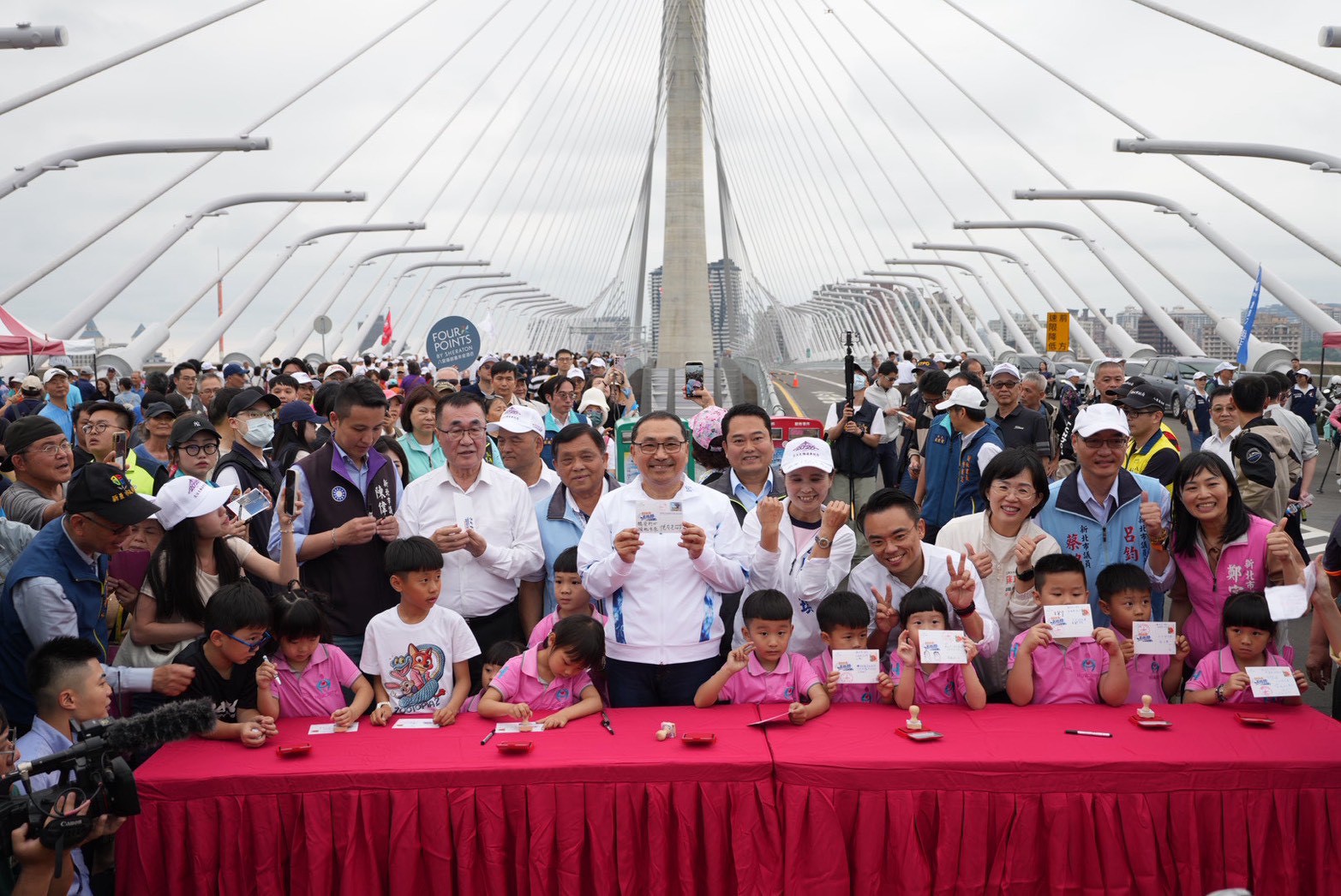 市長侯友宜與幼兒園小朋友一起在紀念明信片上寫下願望、蓋下紀念戳章，投入郵筒，寄託對未來的憧憬。