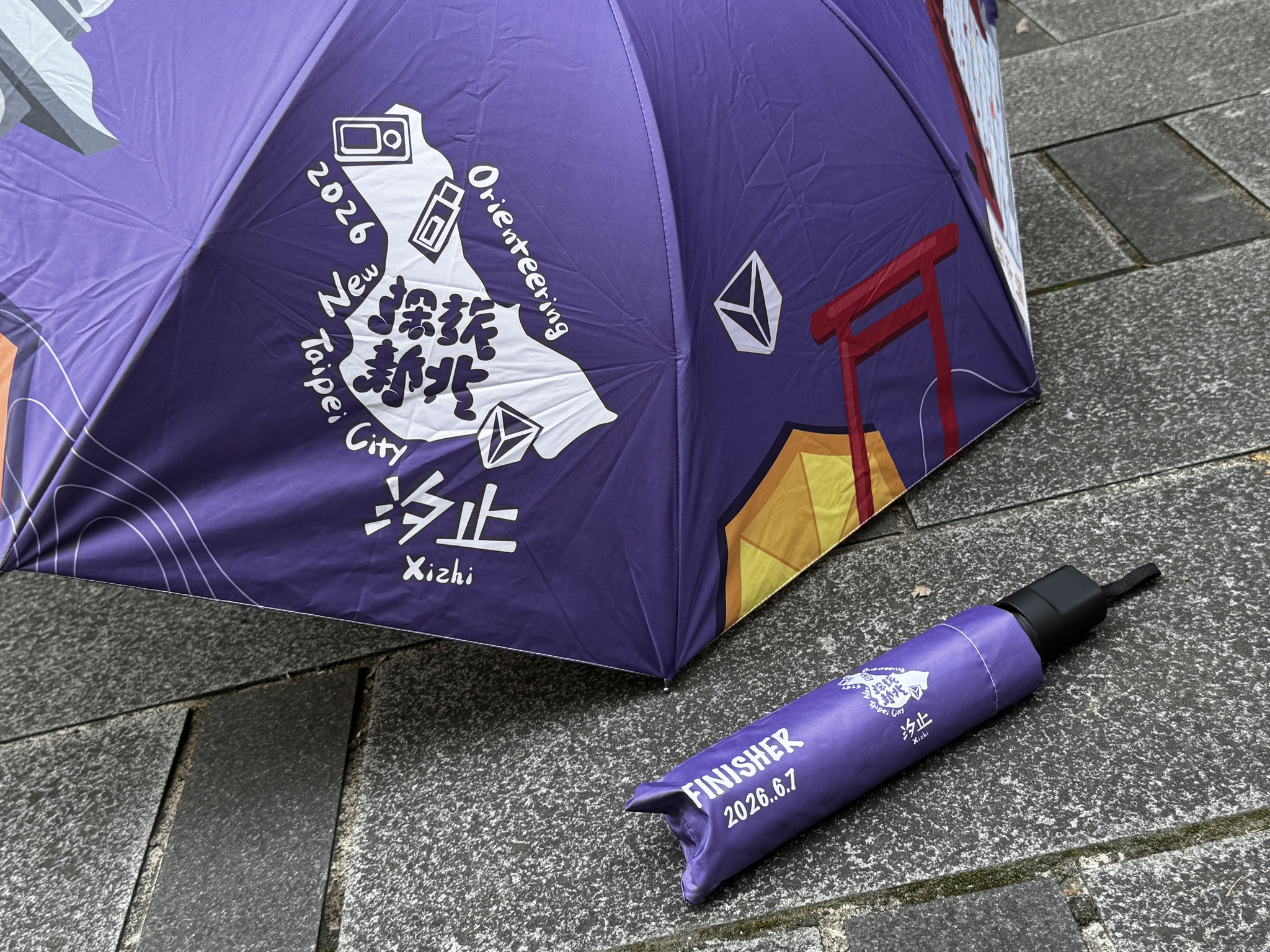  完賽禮特別準備可折疊收納的主題雨傘，呼應汐止多雨的城市印象，也象徵保護、庇護與遮風擋雨的陪伴。