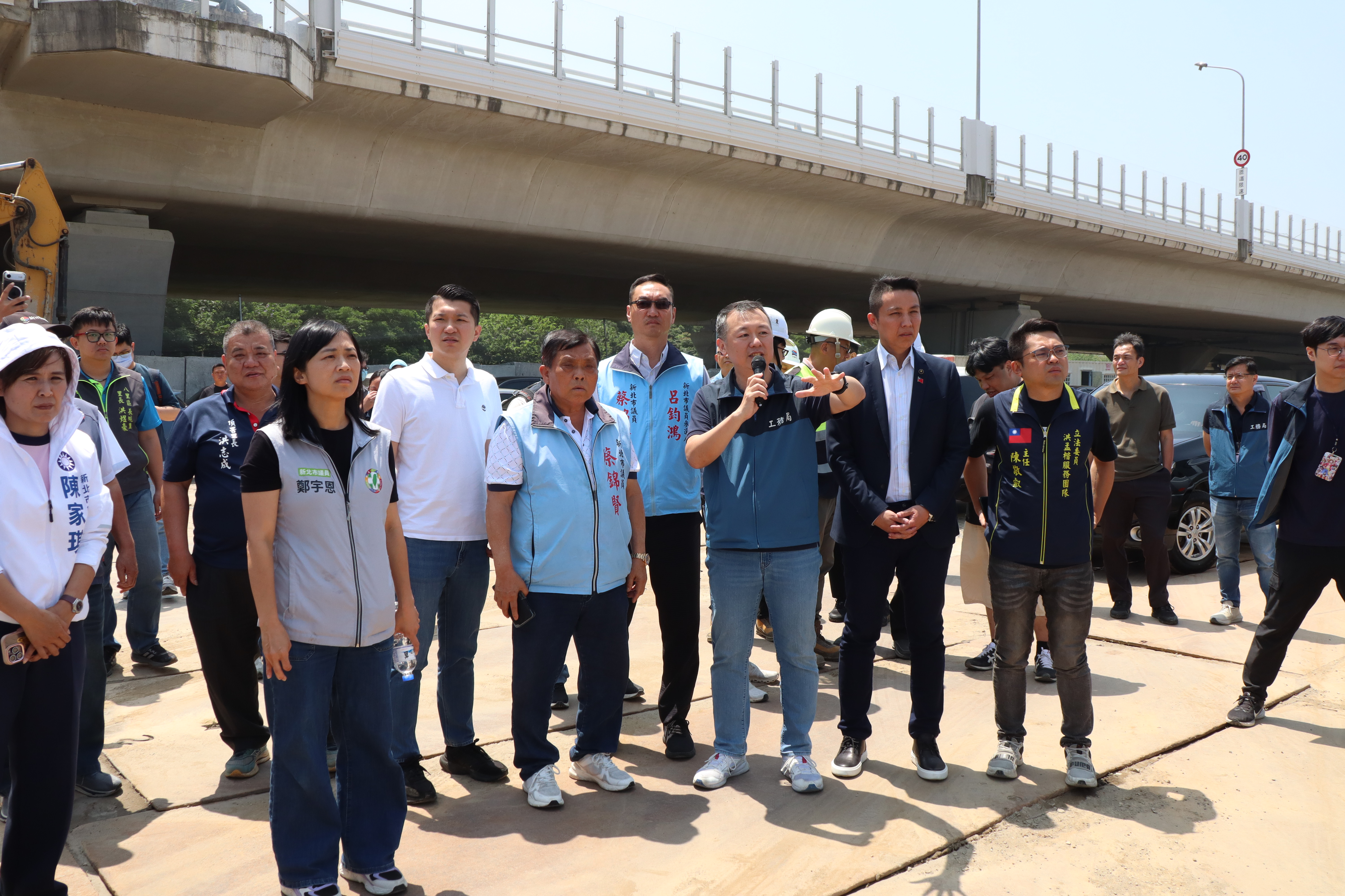 工務局副總工程司陳俊翰(持麥克風者)向議員、里長說明臺北港土方暫置區的試辦情形。