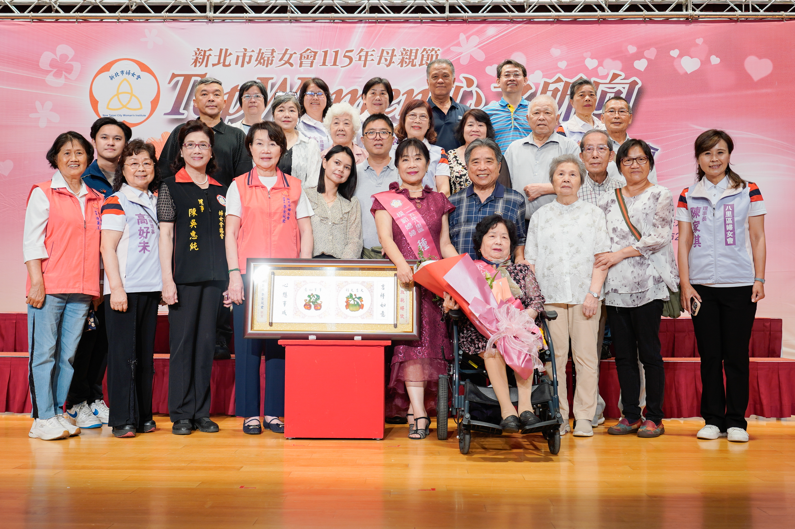  八里區翁瑳（坐輪椅者）和大媳婦種又儀（中）三代同堂，相互照顧，家庭和樂，受到新北市婦女會模範婆媳表揚。