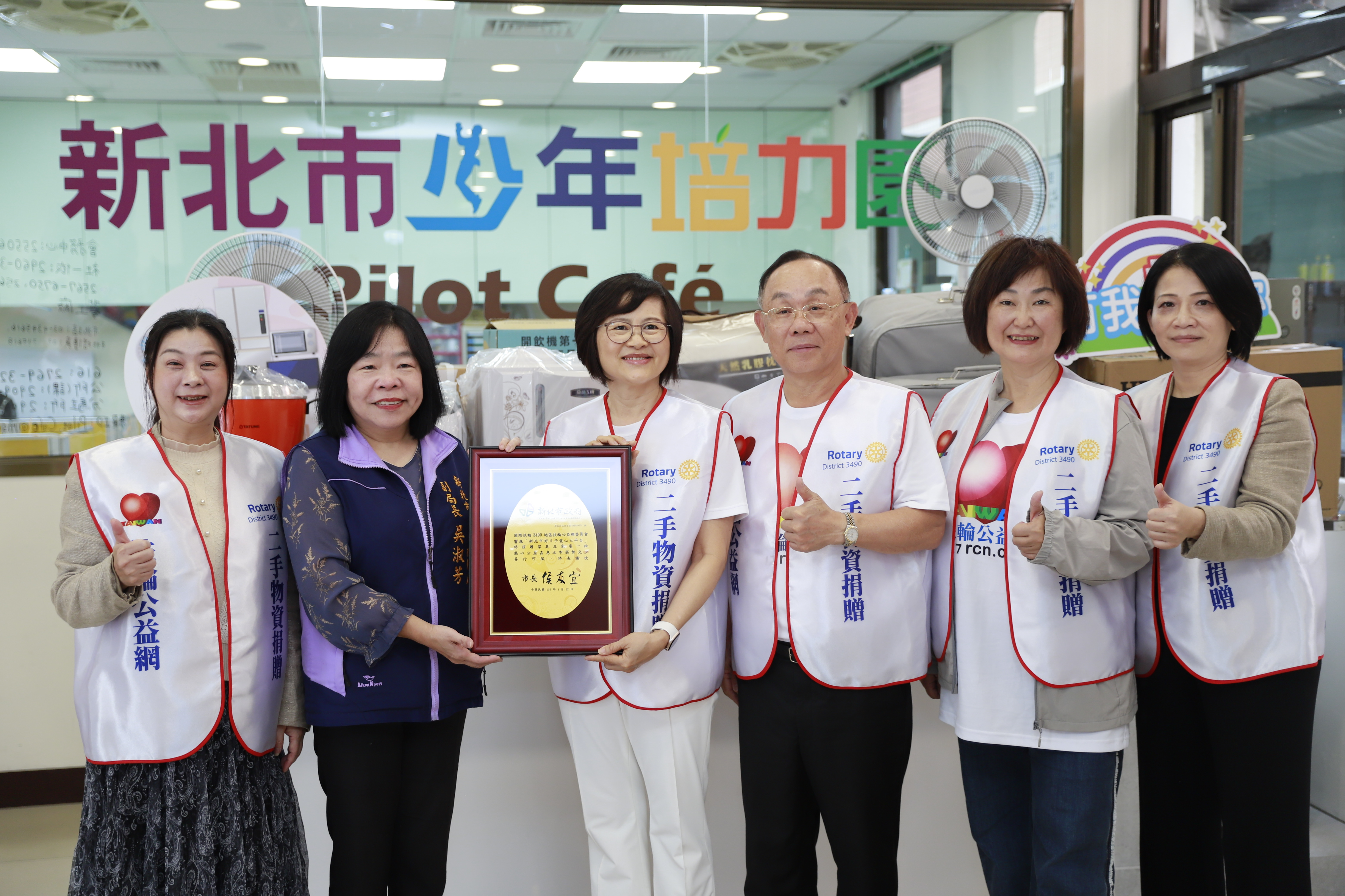  新北市社會局副局長吳淑芳代表侯友宜市長回贈感謝牌給扶輪公益網主委葉淑麗（右4）