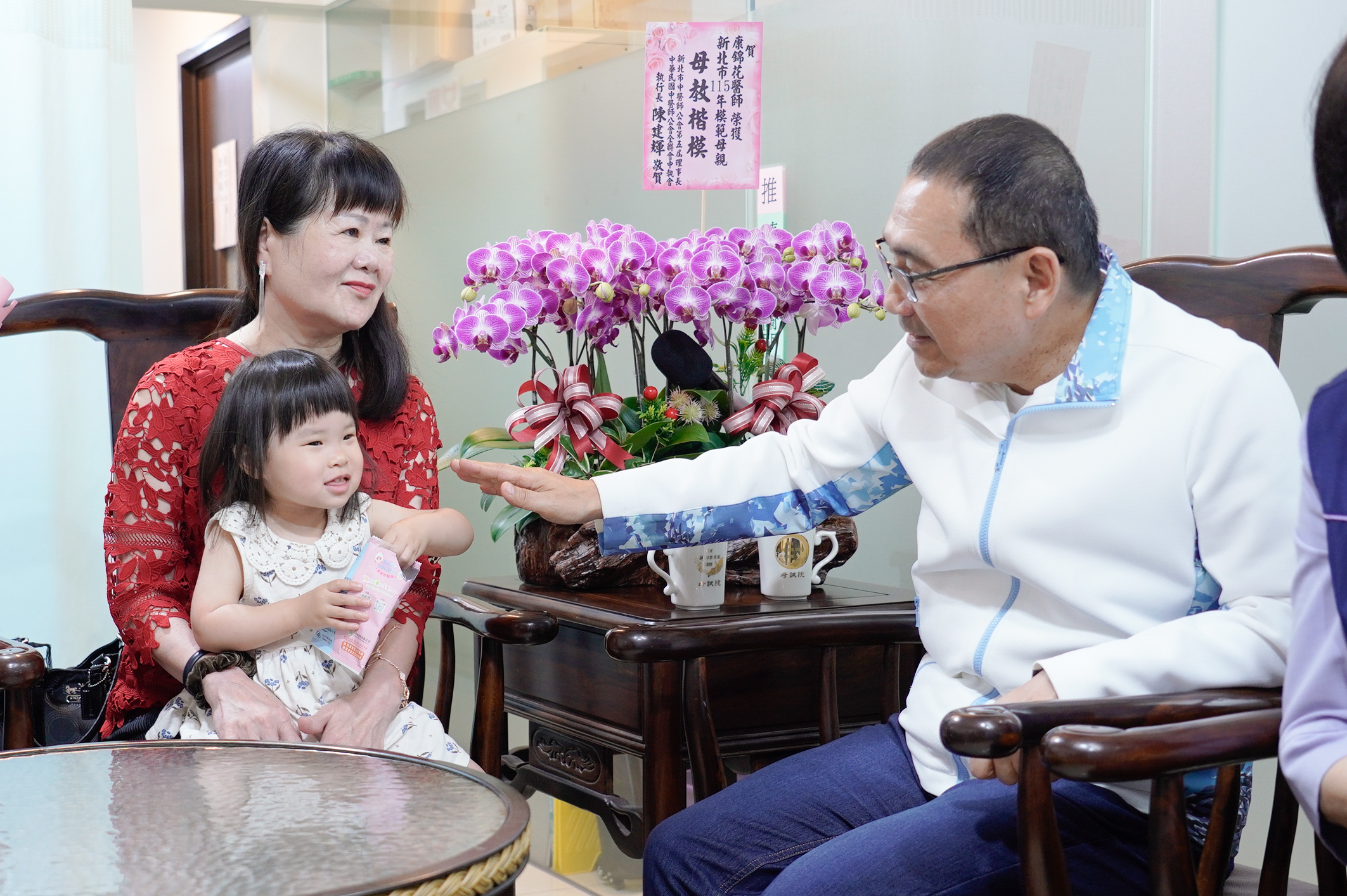 康錦花孫女學說話第一句叫「阿嬤」，令她相當開心，平時也會學阿嬤針灸手勢，侯友宜市長誇小孫女靈巧。