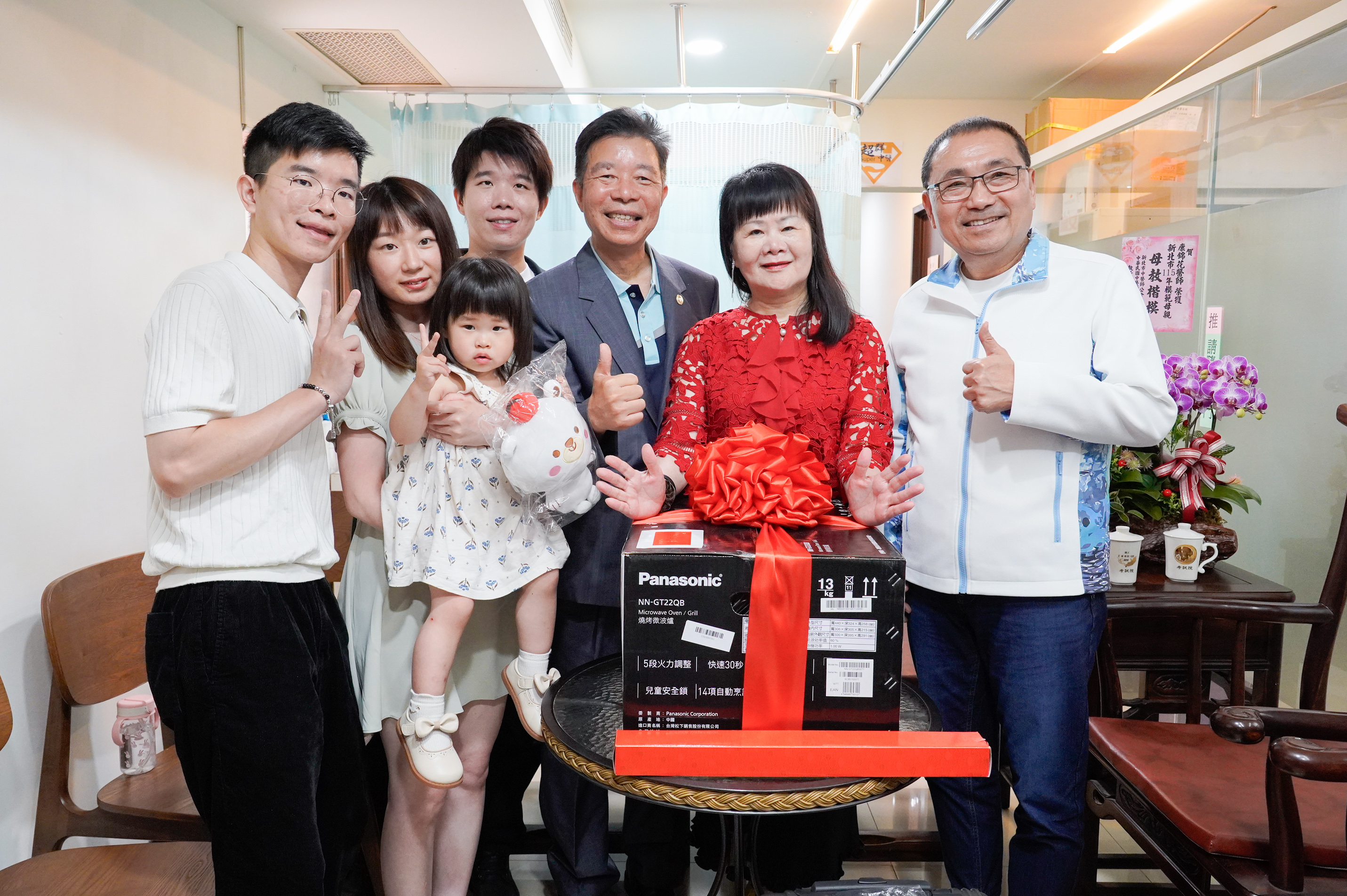  侯友宜致贈模範母親康錦花燒烤微波爐，並與全家人合影。