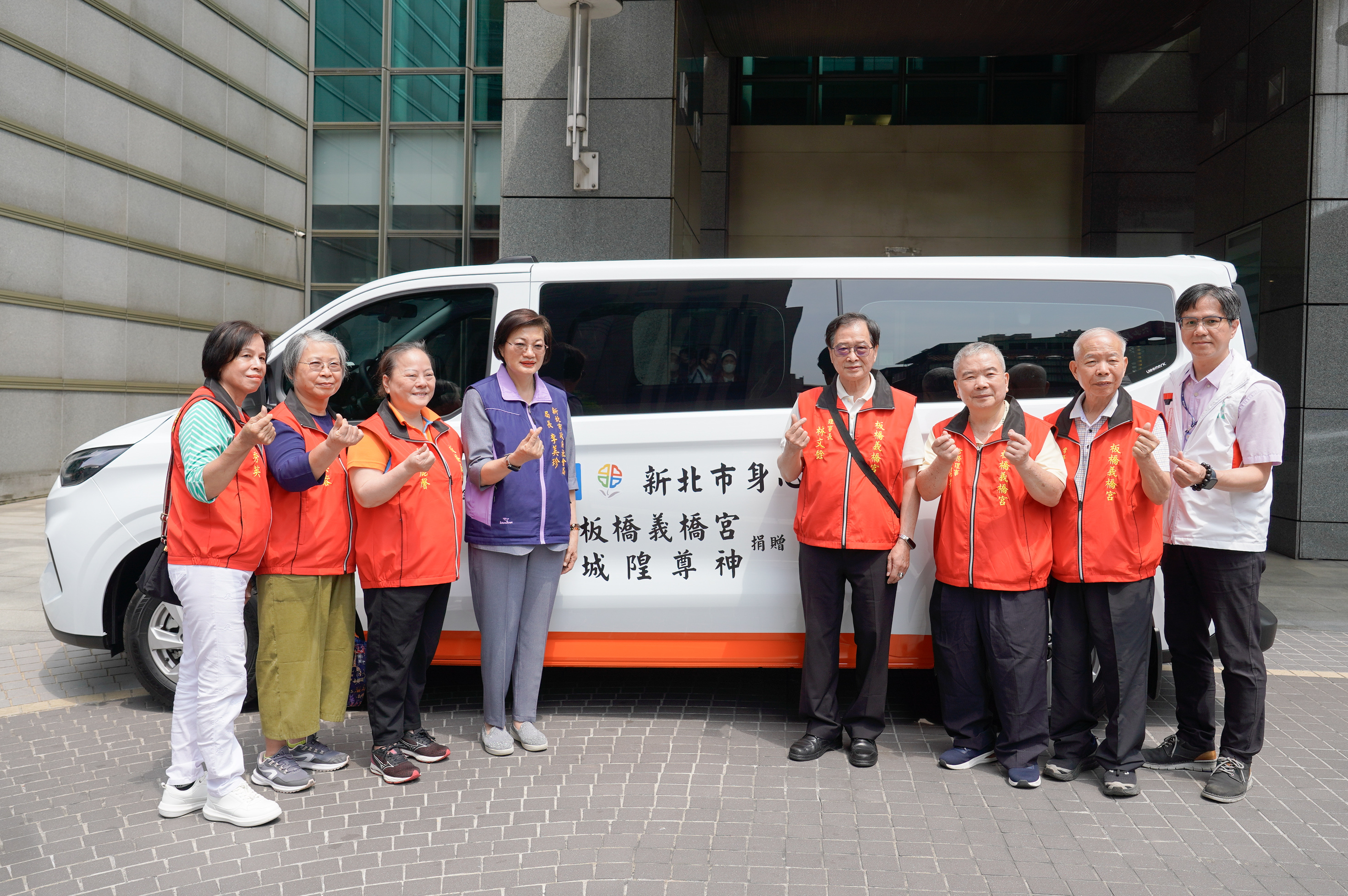 板橋義橋宮由社團法人板橋義橋宮城隍尊神協會理事長林文銓(右四)代表，捐贈雙輪椅座位復康巴士給新北市政府，由社會局長李美珍代表(左四)受贈