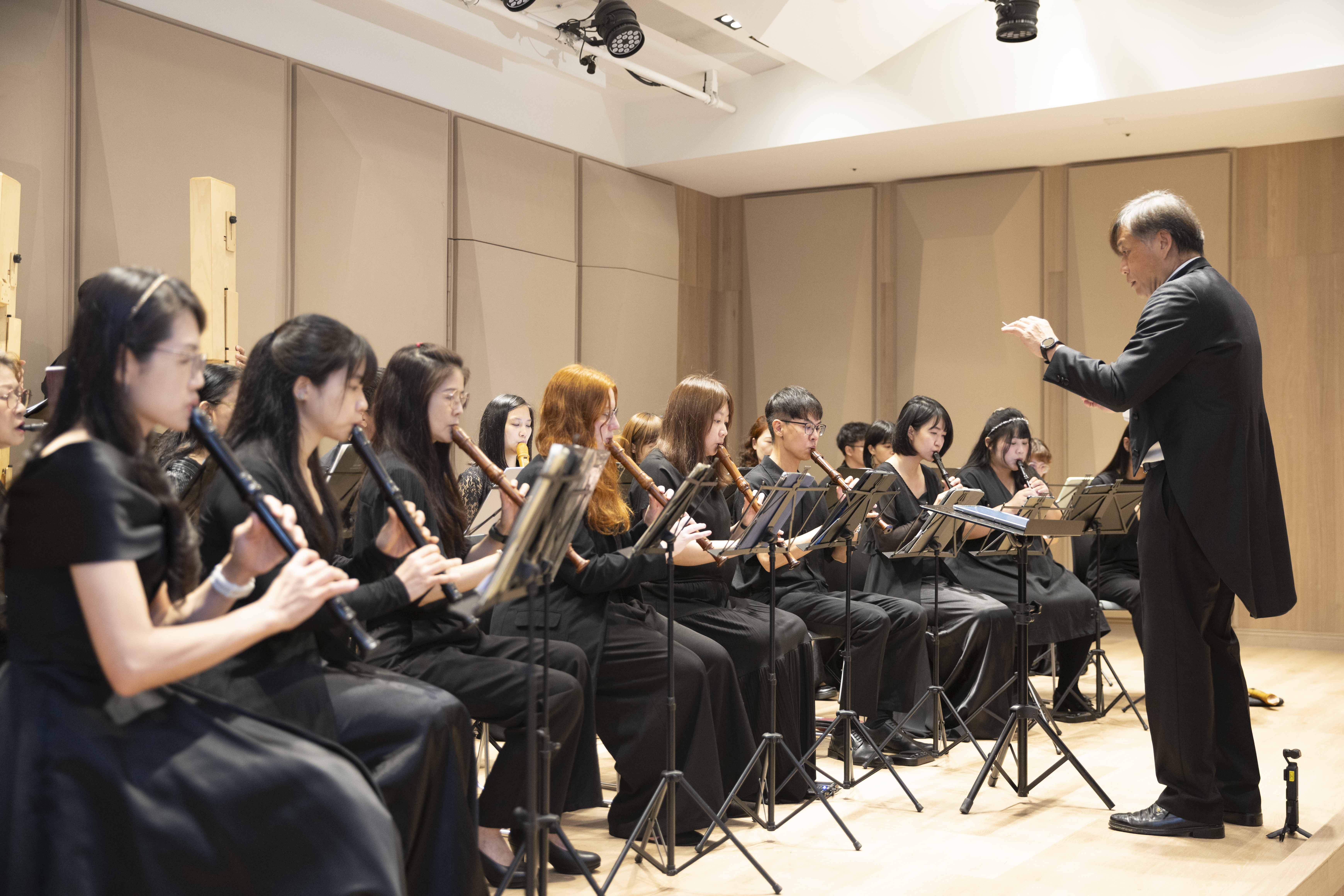 台北木笛合奏團指揮劉永泰（右）帶領團員演奏多首臺灣歌謠及民歌橄欖樹，以饗板一、板二社福中心服務的家庭。