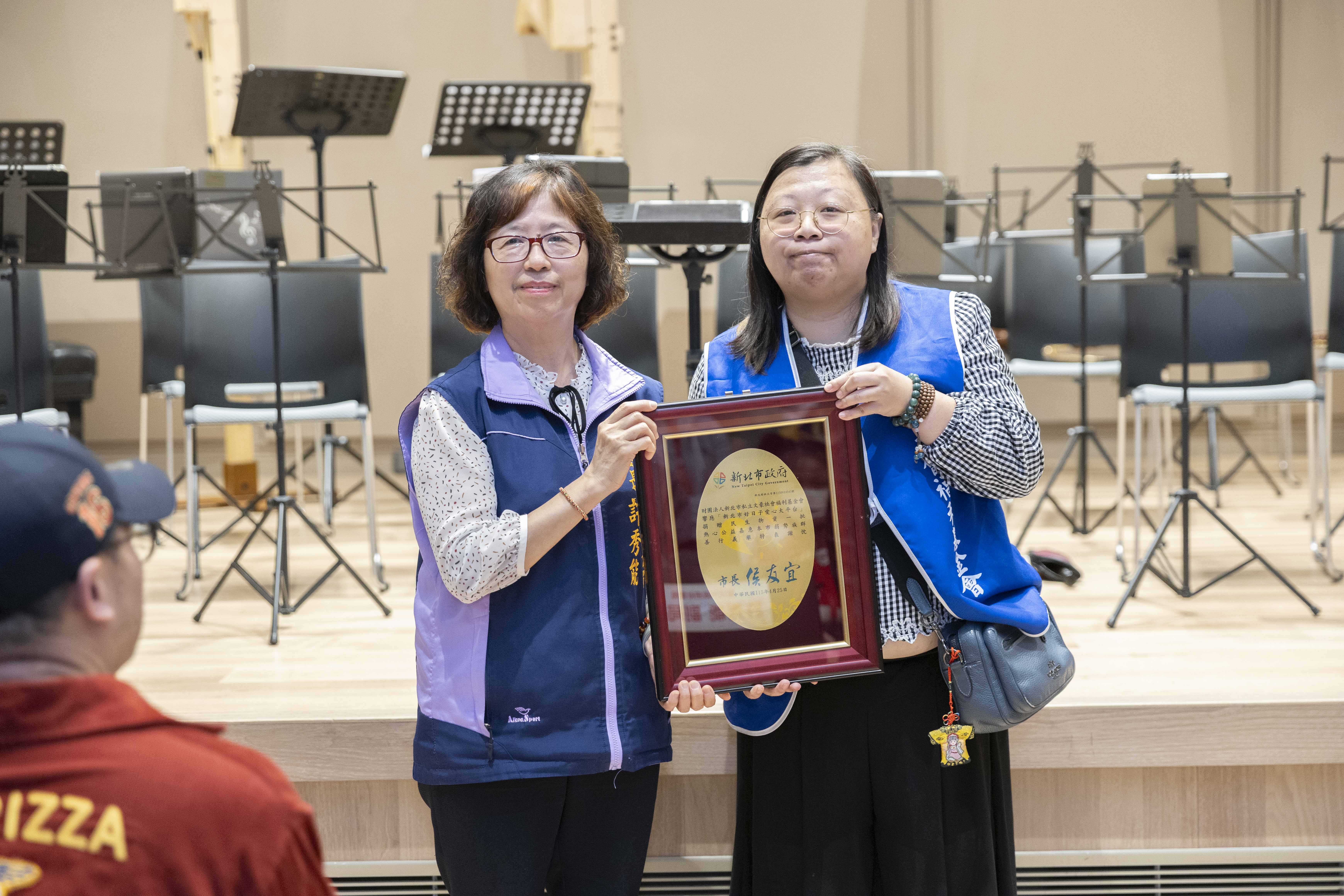 社會局副局長許秀能代表侯友宜市長回贈感謝牌給財團法人新北市私立文豪社會福利基金會代表林映如（右）