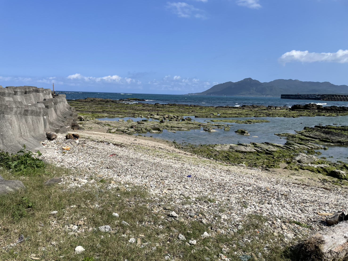 澳仔漁港沿岸潮間帶與步道景致，遠山海景交織成開闊視野