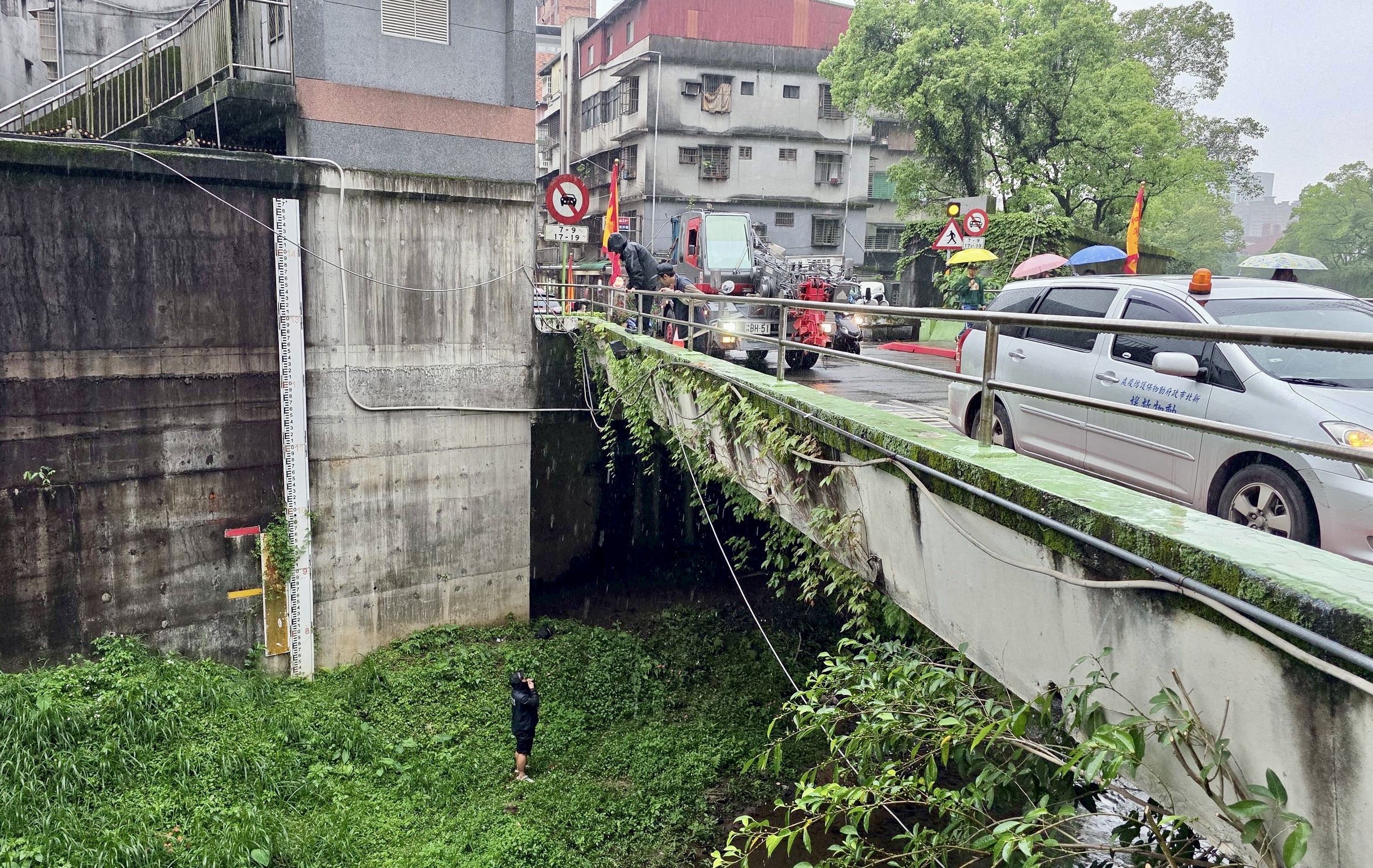 動保員利用吊車下降至河床準備救援
